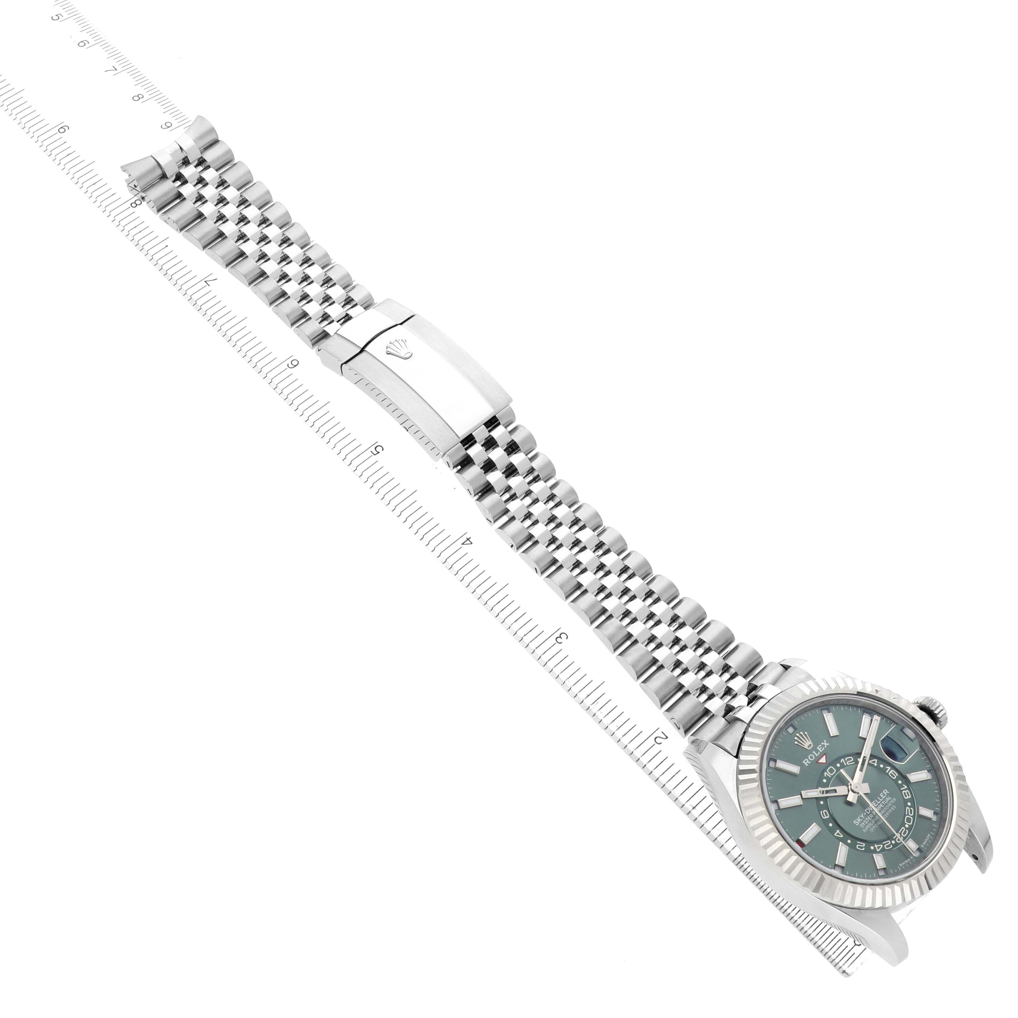 The Rolex Sky-Dweller 336934 Men's Stainless Steel Green Dial watch is shown diagonally, highlighting the face, bezel, and metal bracelet with the clasp visible.
