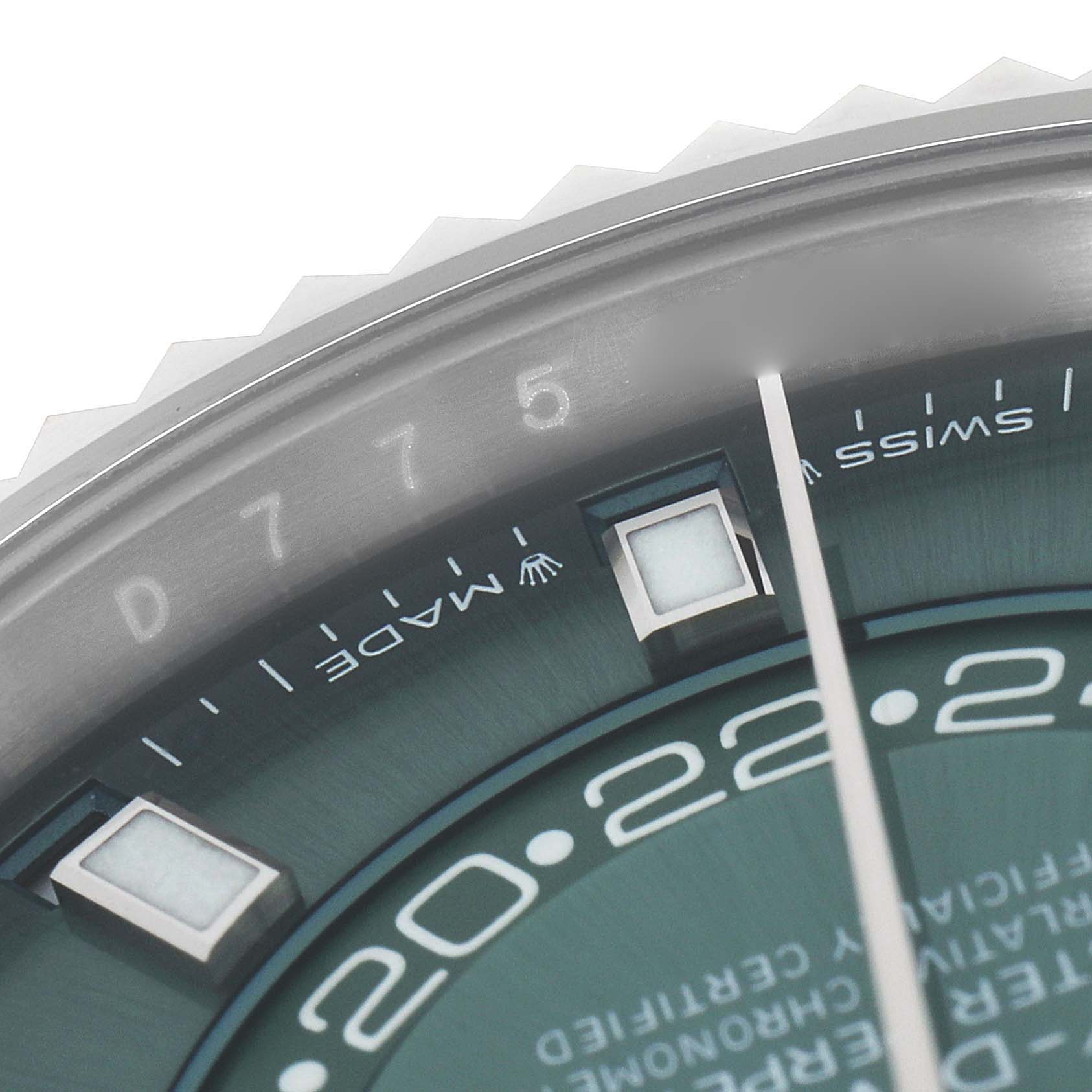 The image shows a close-up of the dial and bezel on a Rolex Sky-Dweller 336934 Men's Stainless Steel Green Dial, focusing on the hour markers and detailed engravings.