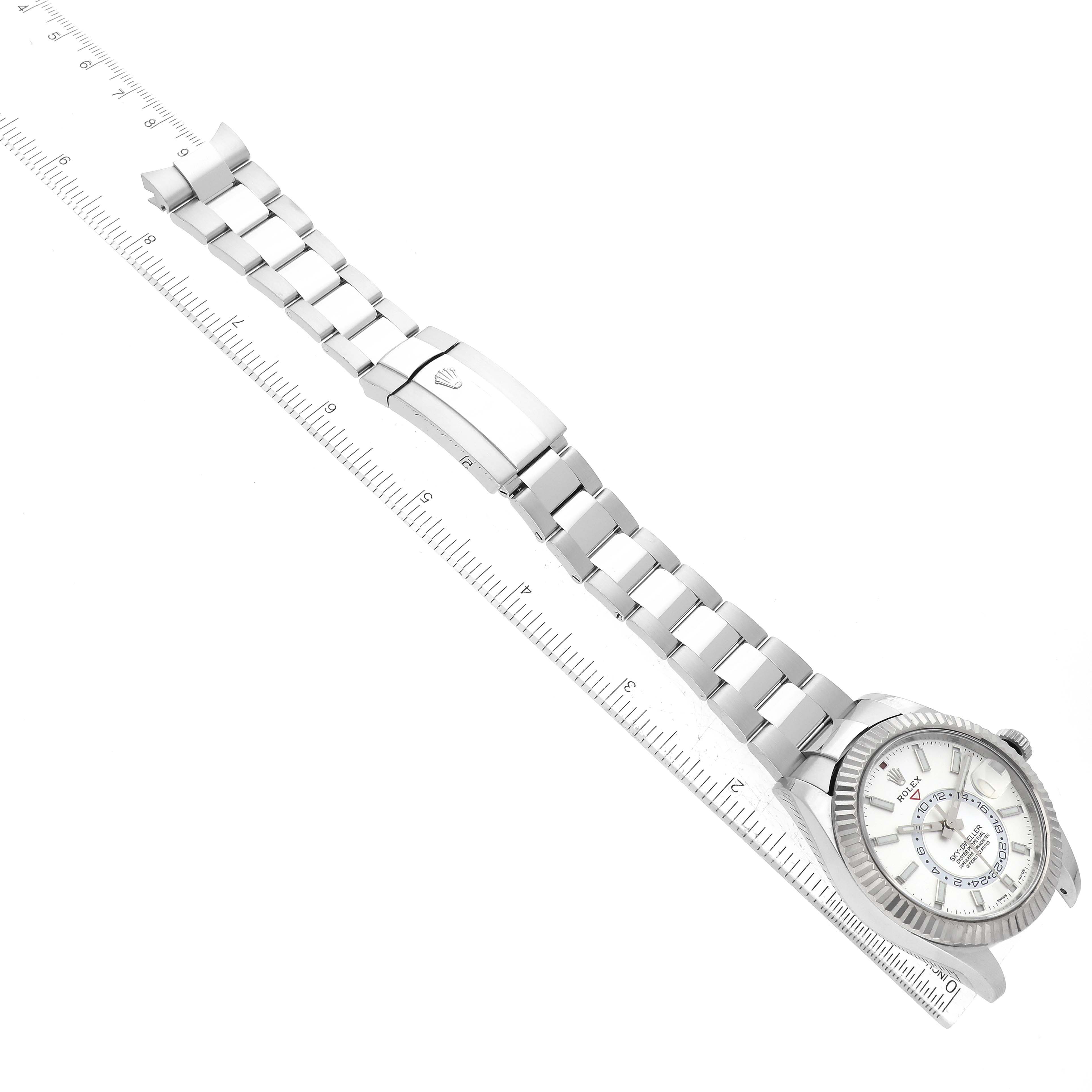 The image shows a side view of the Rolex Sky-Dweller 326934 Men's Stainless Steel Silver Dial 326934 Men's Stainless Steel Silver Dial watch with its stainless steel bracelet laid flat next to a ruler.