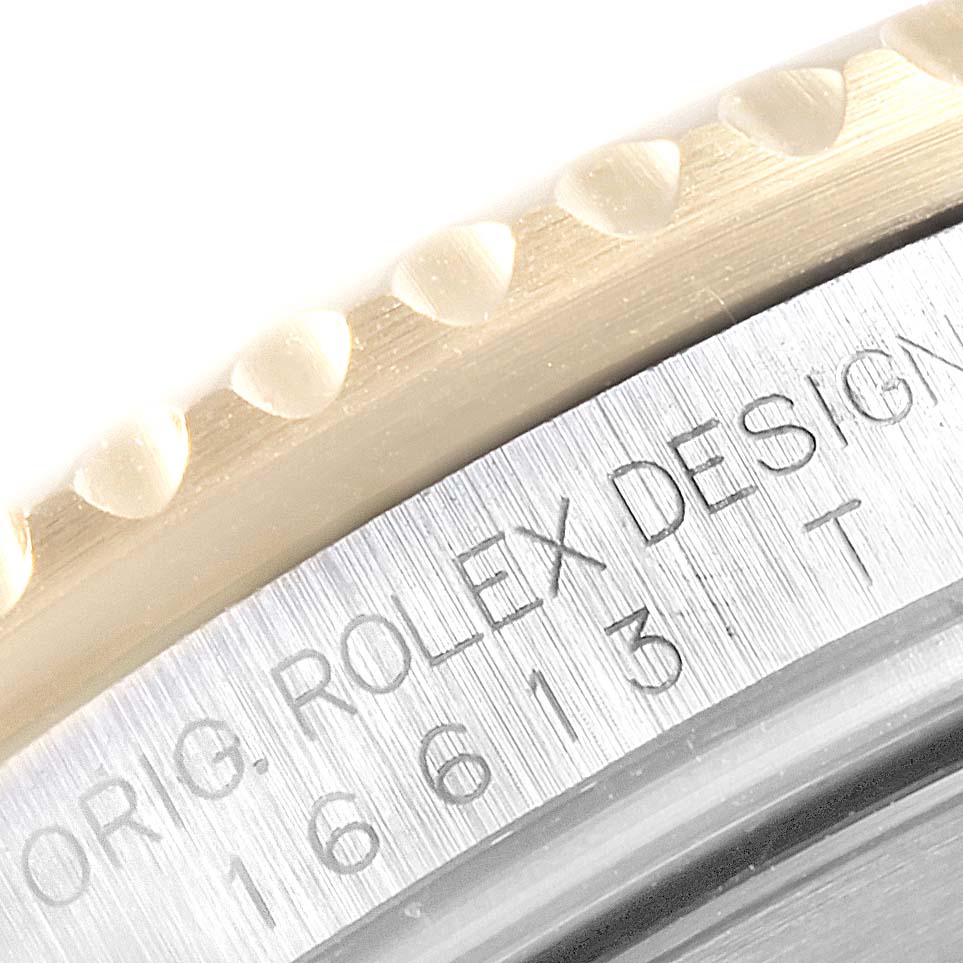 The image shows a close-up of the engraved case side and bezel edge of a Rolex Submariner 16613 Men
s Steel and Gold (two tone) Blue Dial 16613 Men
s Steel and Gold (two tone) Blue Dial watch.