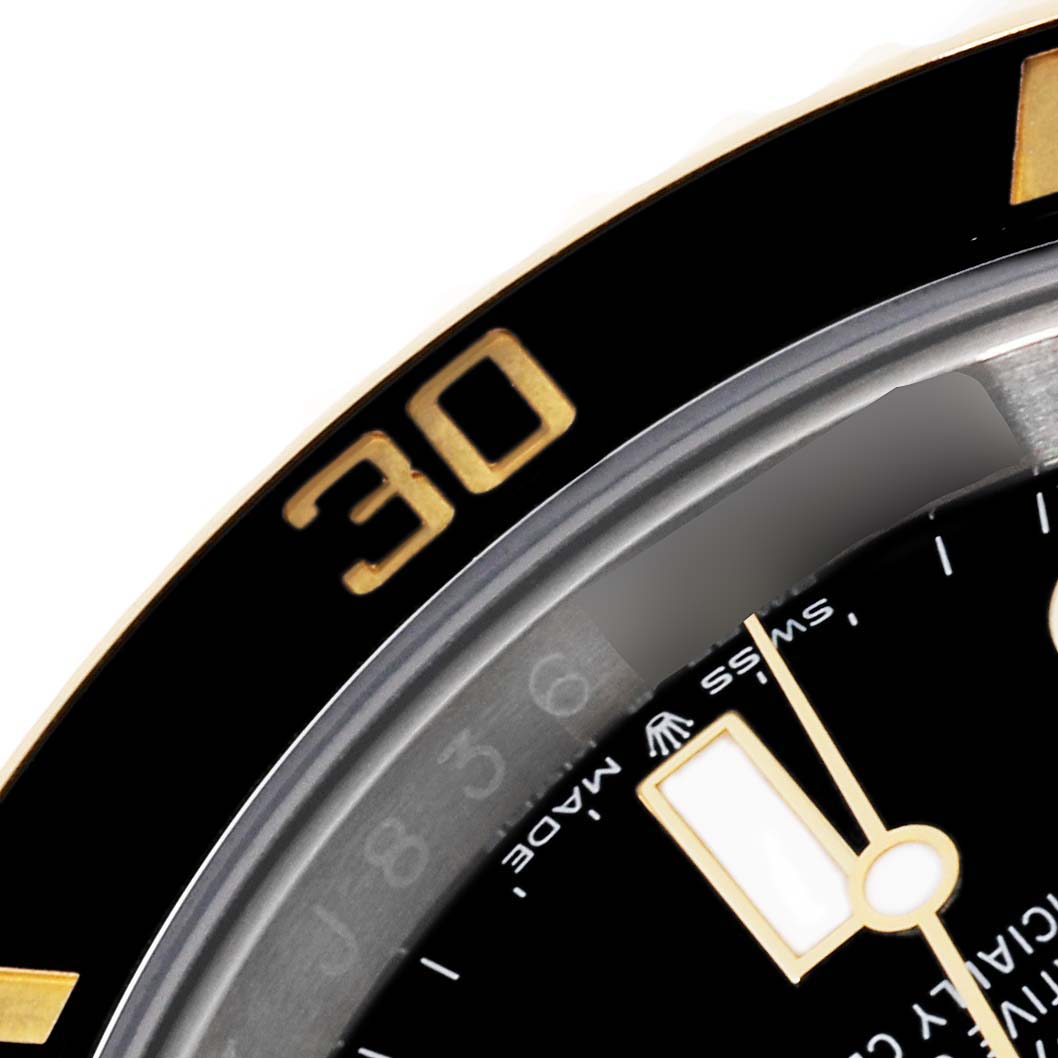 This close-up image of a Rolex Submariner 126613LN Men's Steel and Gold (two tone) Black Dial 126613LN Men's Steel and Gold (two tone) Black Dial watch shows the bezel with the 30-minute marker and part of the dial and hands.