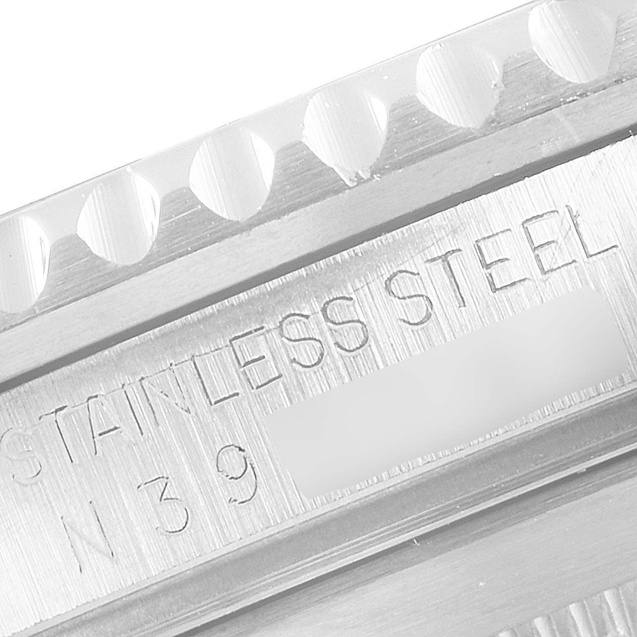 This close-up image shows the bezel teeth and part of the inner watch case, featuring "STAINLESS STEEL" on a Rolex Submariner 16610 Men's Stainless Steel Black Dial 16610 Men's Stainless Steel Black Dial model.