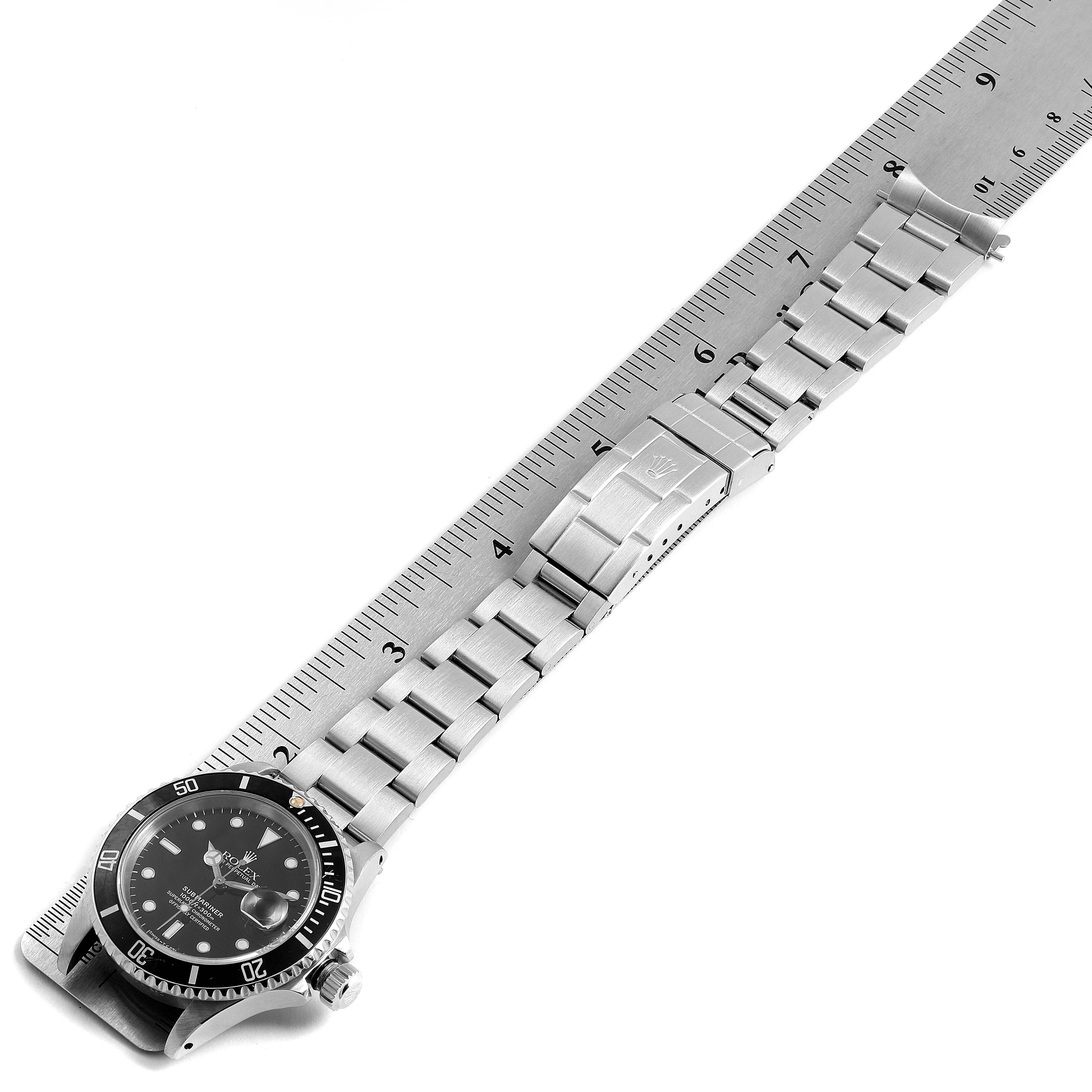 The image shows a Rolex Submariner 16610 Men's Stainless Steel Black Dial 16610 Men's Stainless Steel Black Dial watch lying flat with its bracelet extended alongside a ruler for measuring.