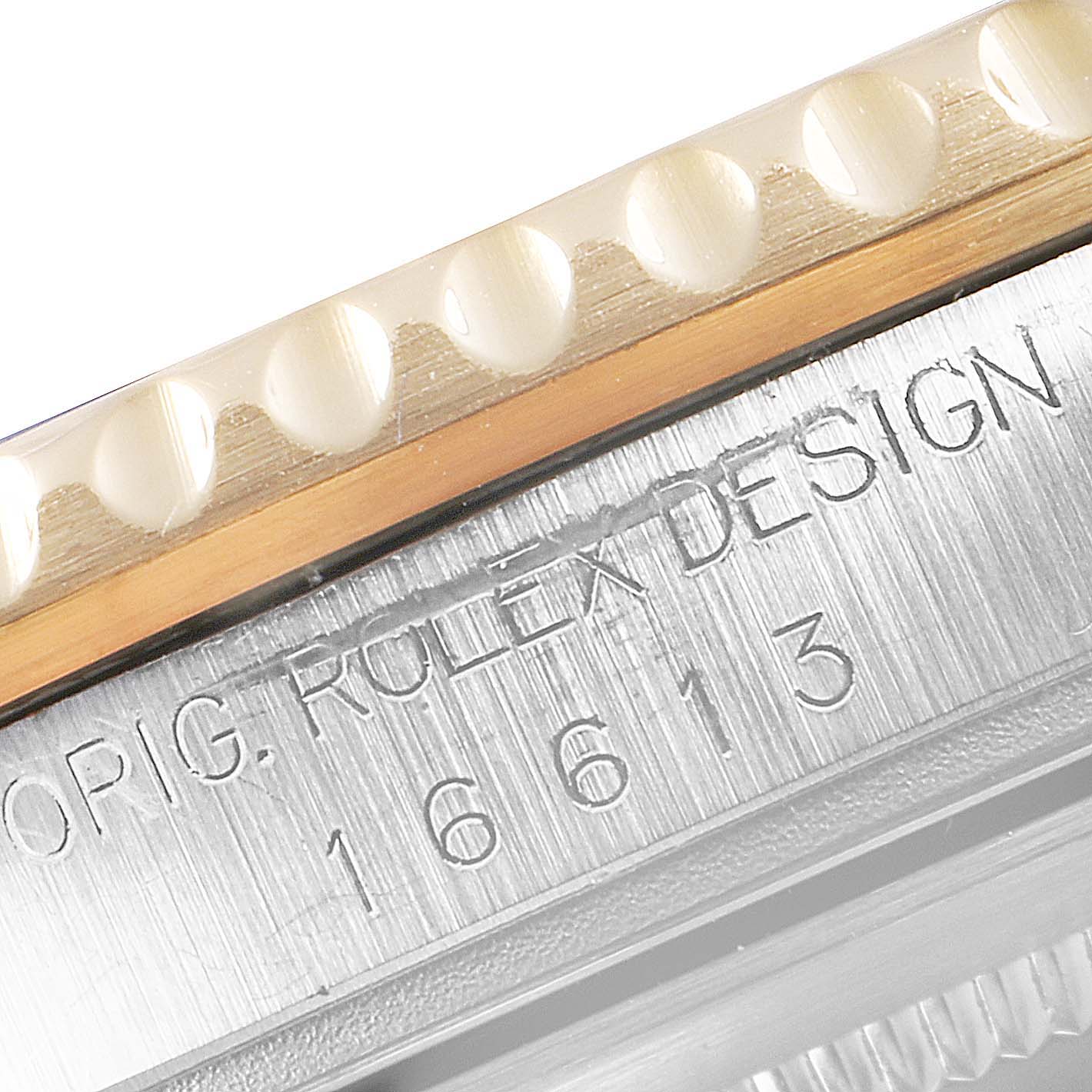 This close-up image of a Rolex Submariner 16613 Men
s Steel and Gold (two tone) Blue Dial 16613 Men
s Steel and Gold (two tone) Blue Dial watch shows the bezel and the engraved case edge.