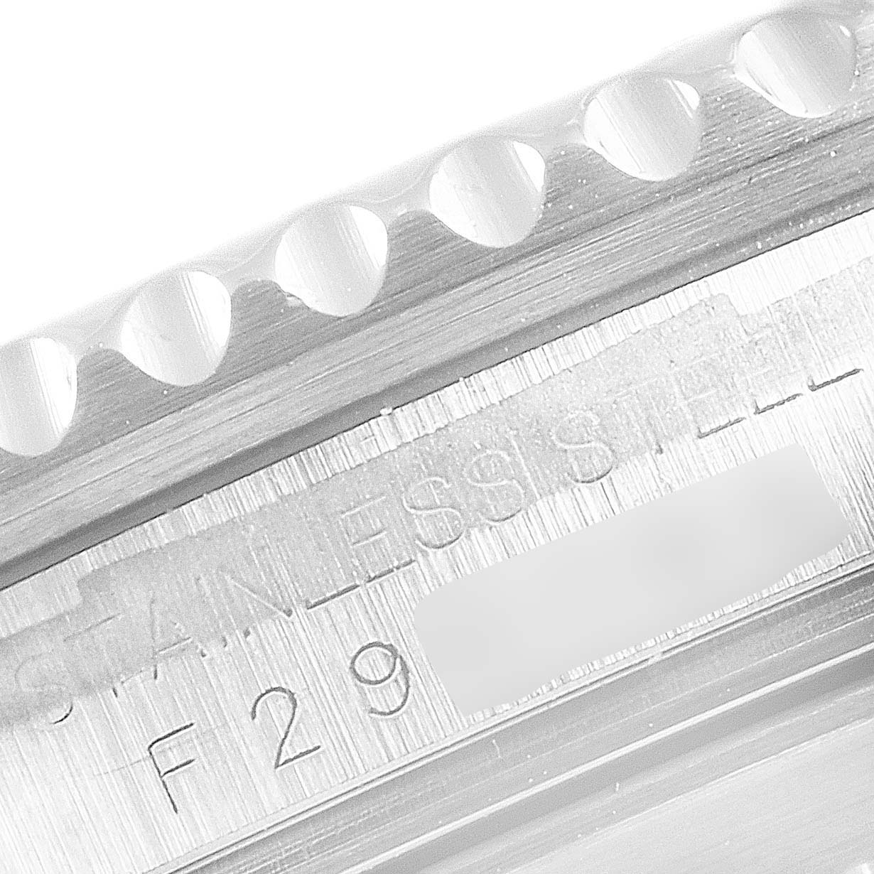 This image shows a close-up of the Rolex Submariner 16610 Men's Stainless Steel Black Dial 16610 Men's Stainless Steel Black Dial's stainless steel bezel and serial number.