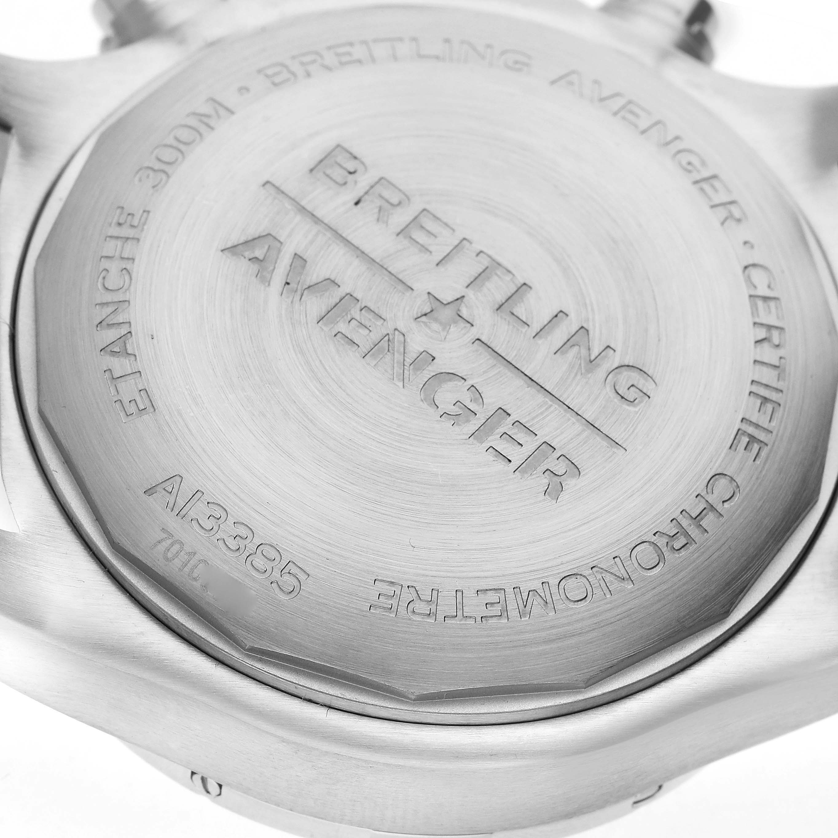 The image shows the back case of a Breitling Avenger A13385 Men's Stainless Steel Black Dial watch, highlighting engravings and the brushed metal finish.