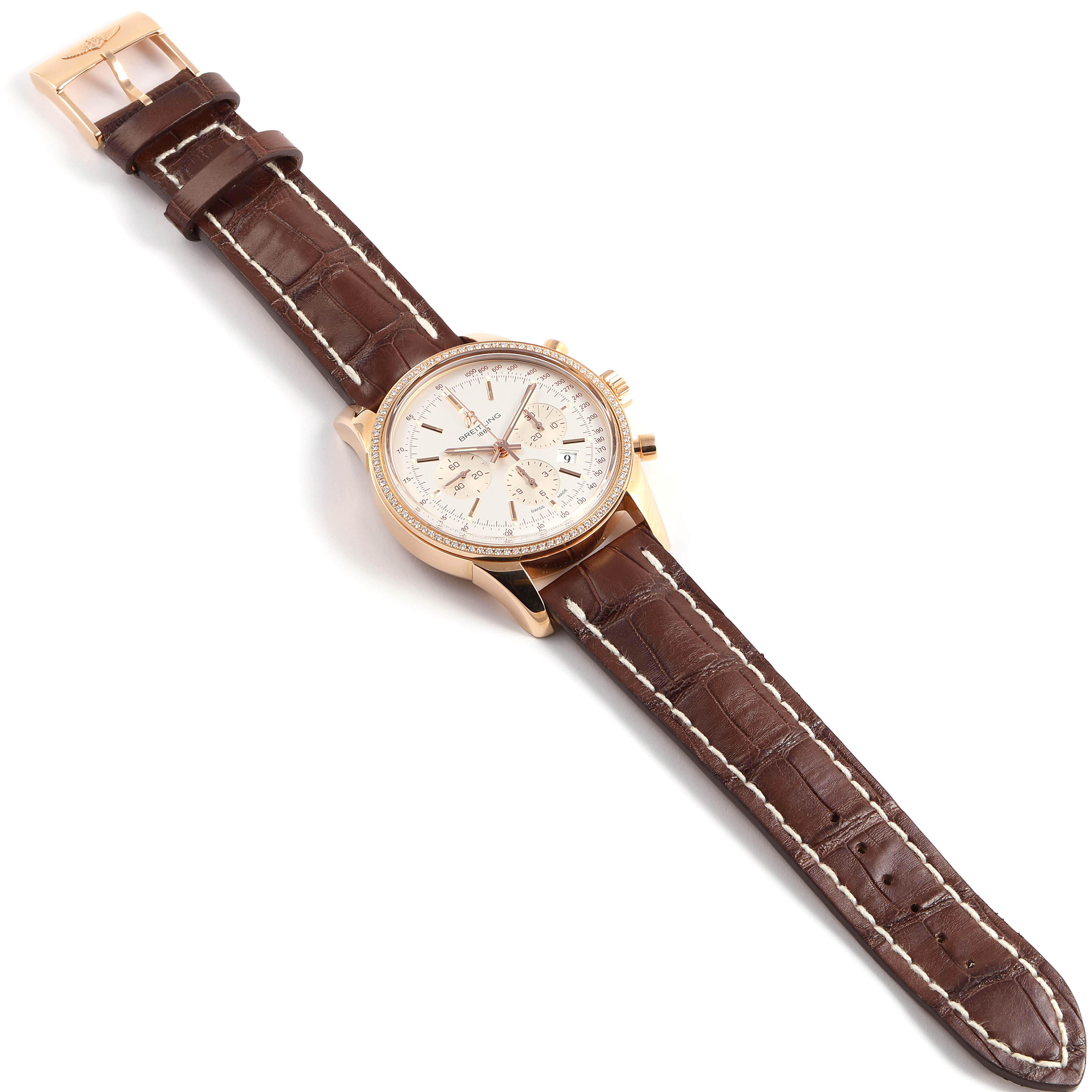 The Breitling Transocean RB0152 Men's Rose Gold Silver Dial RB0152 Men's Rose Gold Silver Dial watch is shown at an angled top-down view, displaying its brown leather strap and rose gold case.