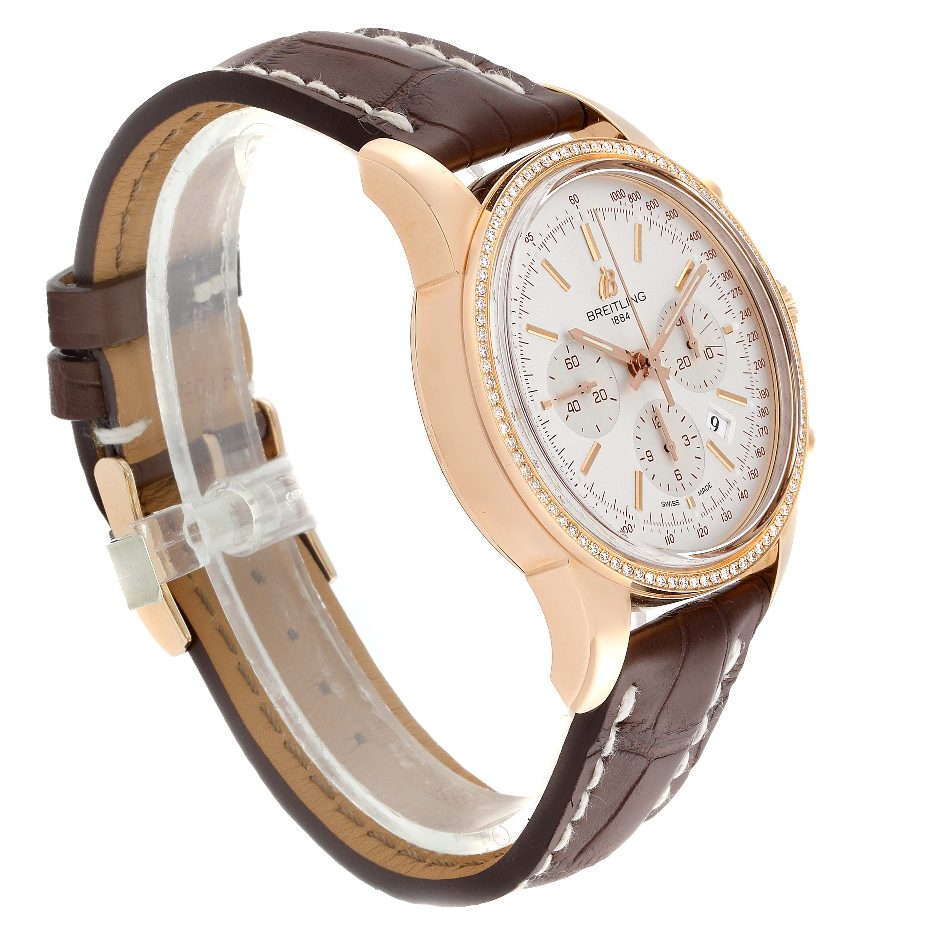 The image shows a side angle of a Breitling Transocean RB0152 Men's Rose Gold Silver Dial RB0152 Men's Rose Gold Silver Dial watch featuring a brown leather strap and gold casing.