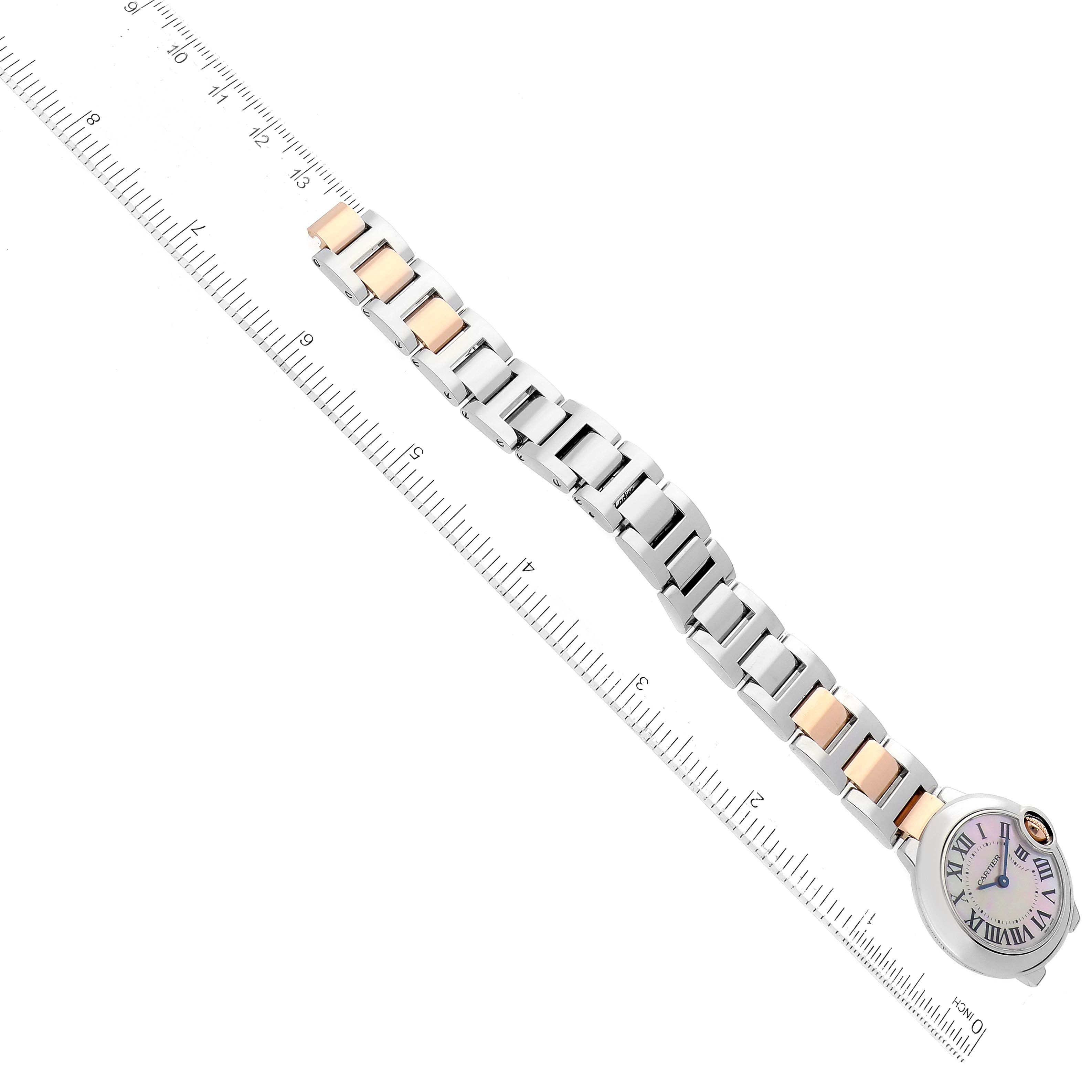 The image shows a Cartier Ballon Bleu W6920034 Women's Steel and Gold (two tone) Mother of Pearl Dial W6920034 Women's Steel and Gold (two tone) Mother of Pearl Dial watch laid flat against a ruler, displaying its bracelet and watch face from a top-down angle.