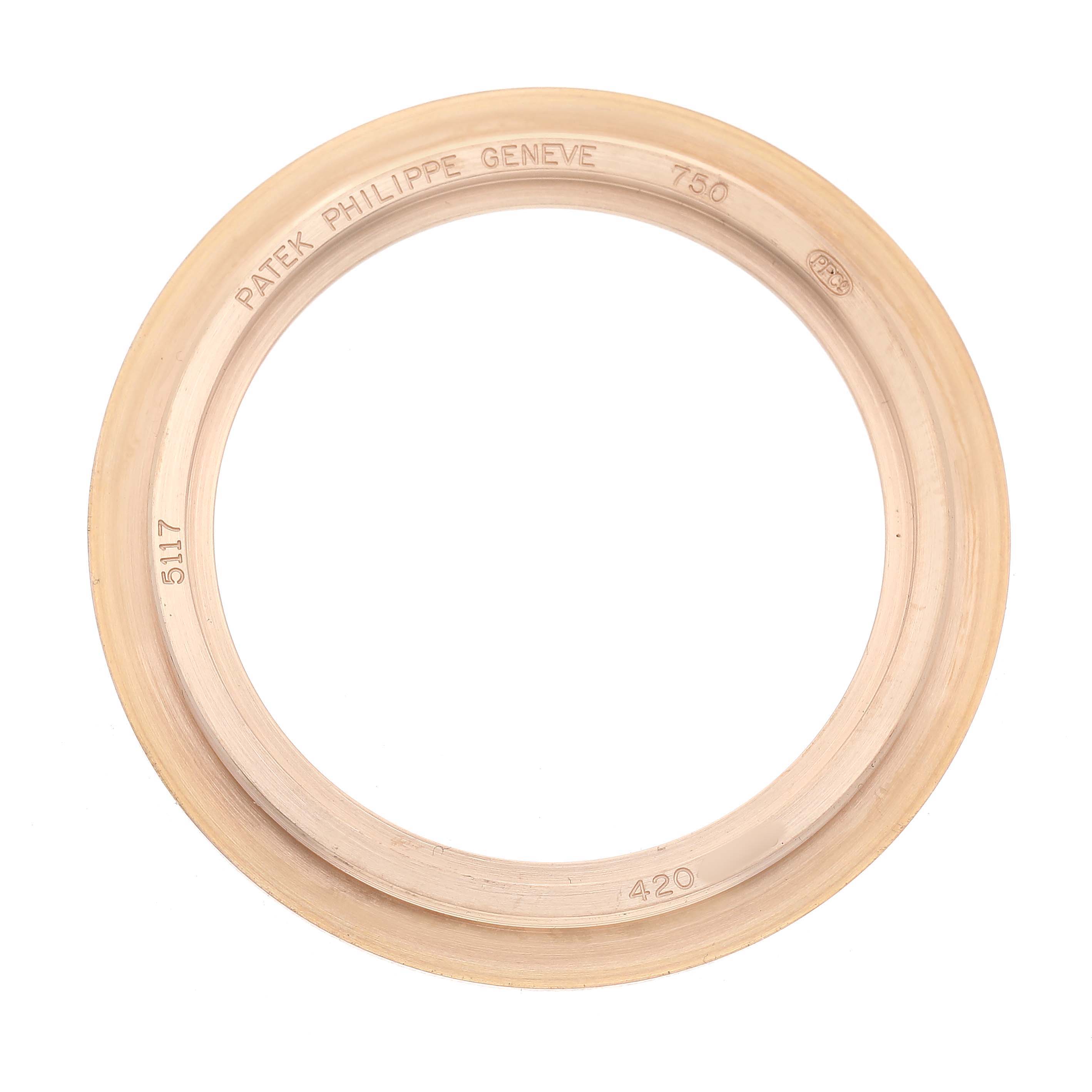 The image shows a top view of the bezel for a Patek Philippe Calatrava 5117R-001 Mens Rose Gold White Dial watch, engraved with brand details and numbers.
