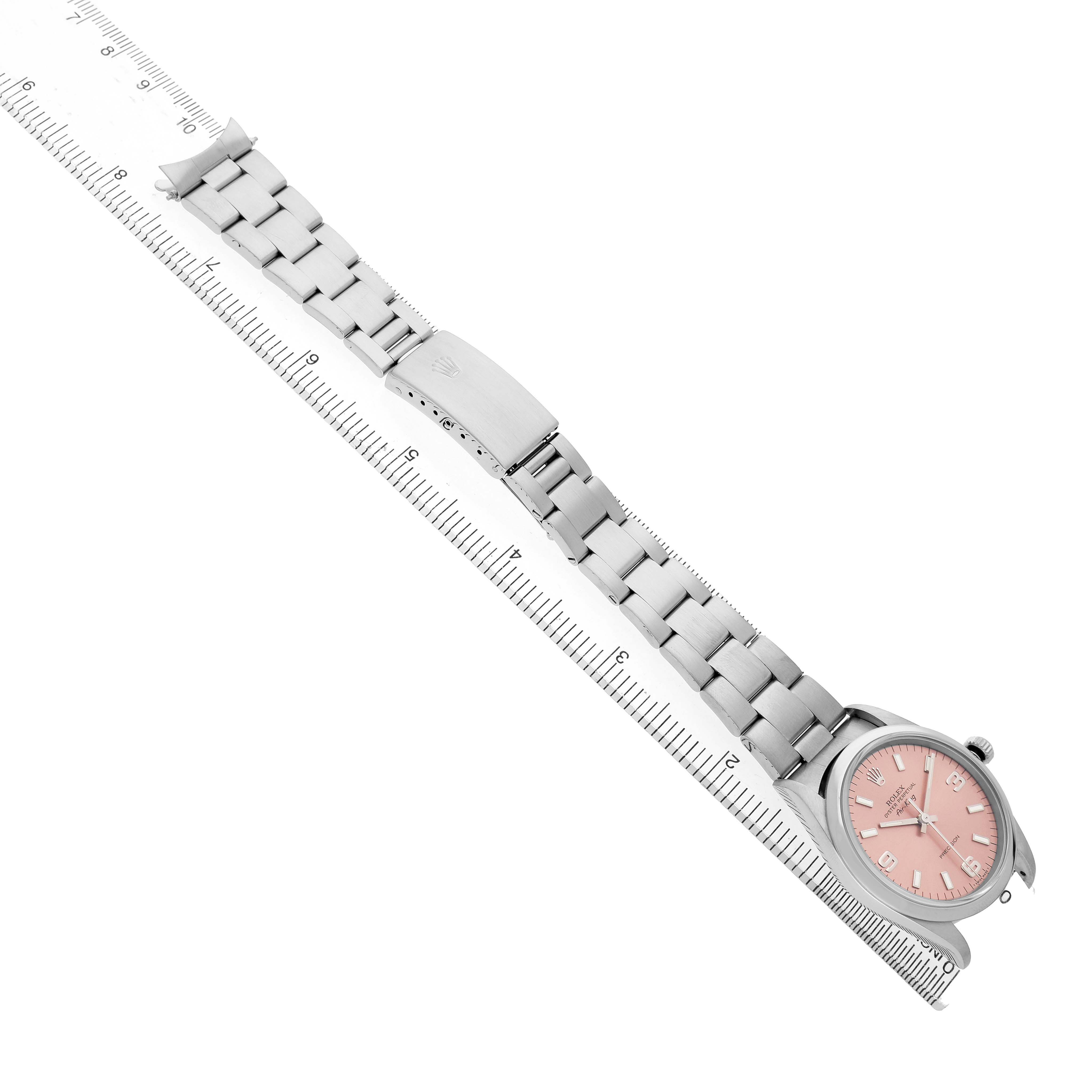 The Rolex Air-King 14000 Mens Stainless Steel Pink Dial watch is shown diagonally with a full view of the face, bracelet, and clasp next to a ruler for scale.