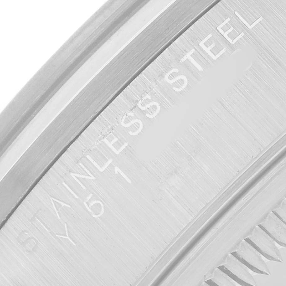 The image shows a close-up of the Rolex Date 15200 Men's Stainless Steel Black Dial watch's stainless steel case, highlighting the engraved text.