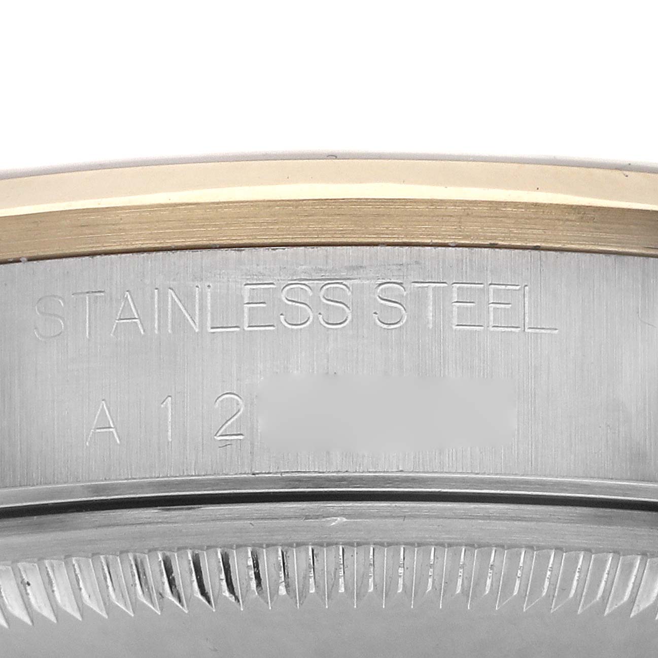 The image shows a close-up of the side of a Rolex Date 15203 Men's Steel and Gold (two tone) Champagne Dial model, featuring the stainless steel casing and engraved details.