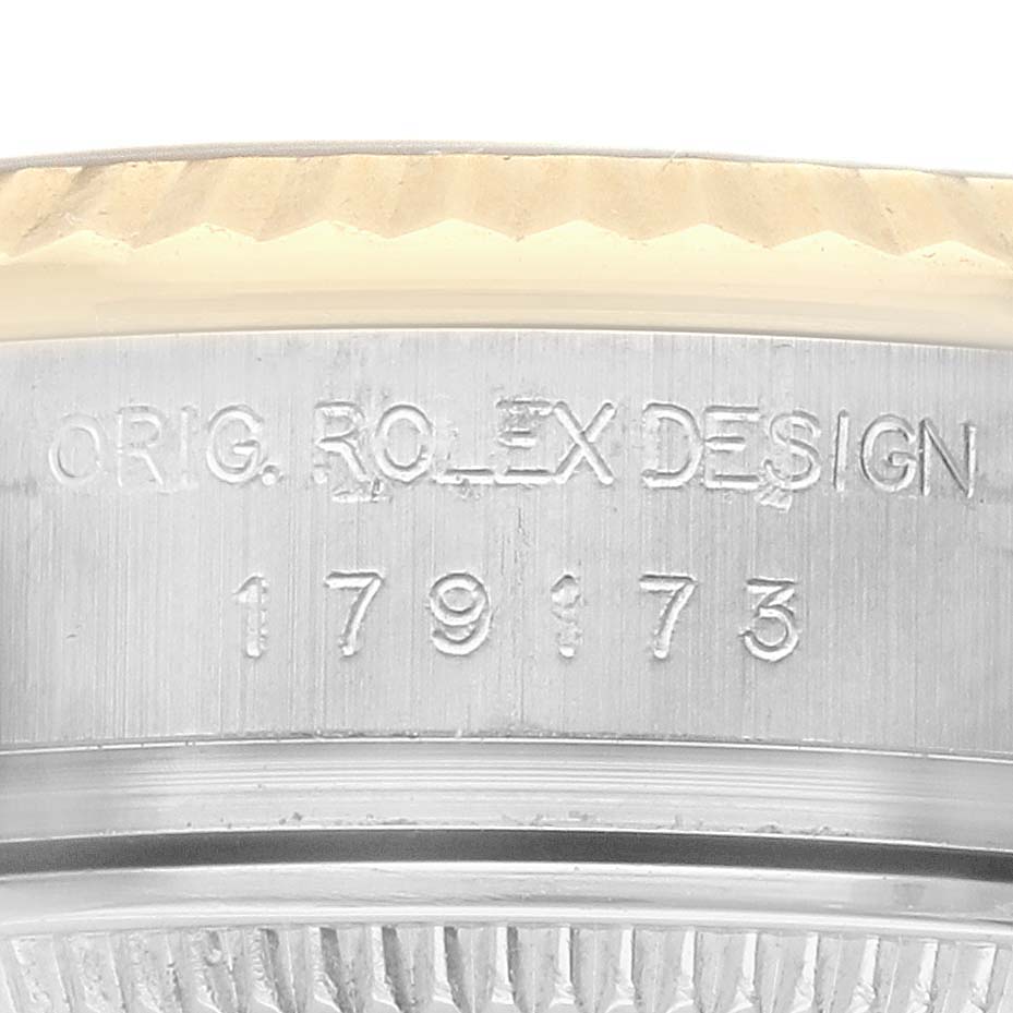 The image shows a close-up of the side of a Rolex Datejust 179173 Women's Yellow Gold Champagne Dial model, featuring its engraved serial and design numbers.