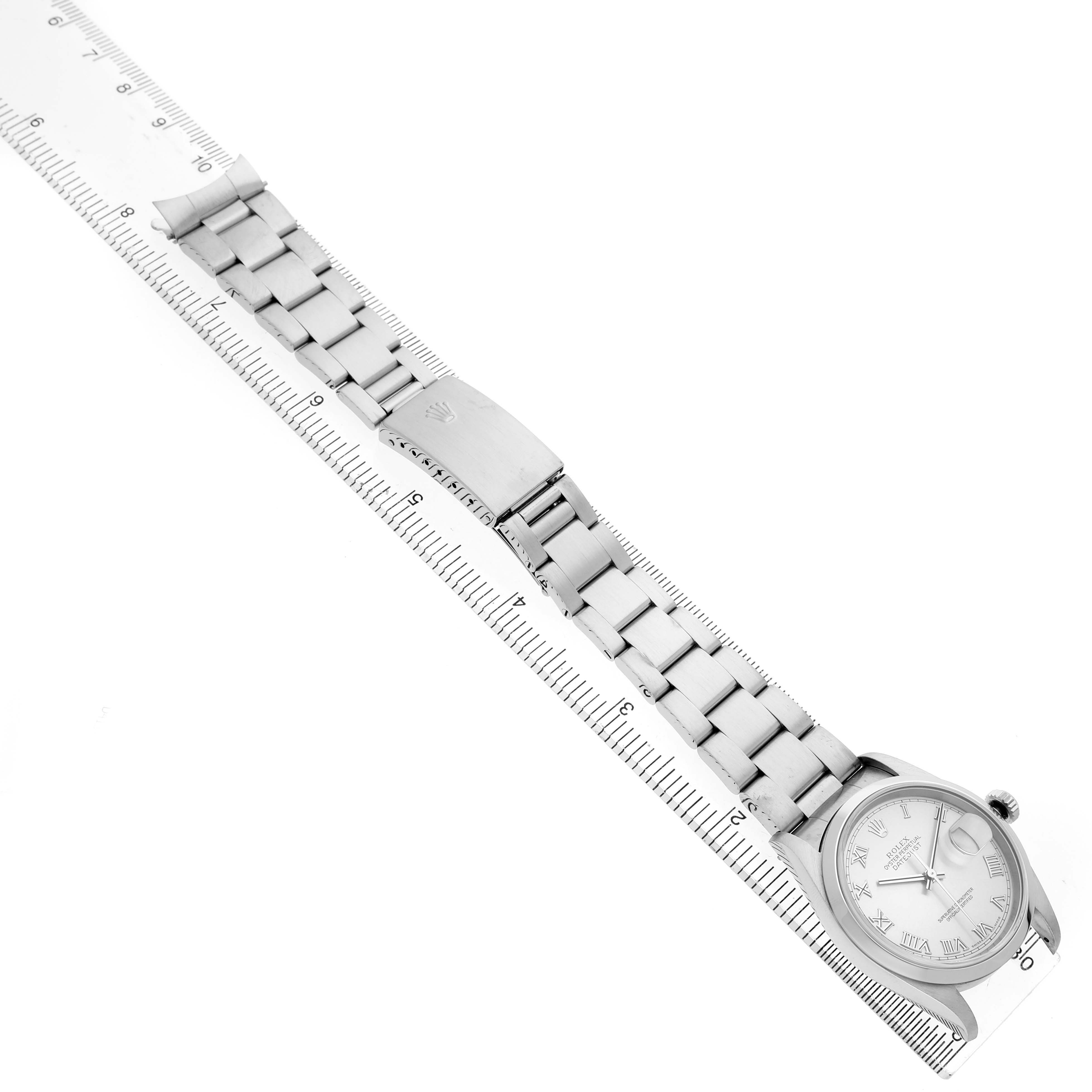 The image shows a Rolex Datejust 16200 Mens Stainless Steel Silver Dial watch diagonally laid out with a ruler, displaying the bracelet and face.
