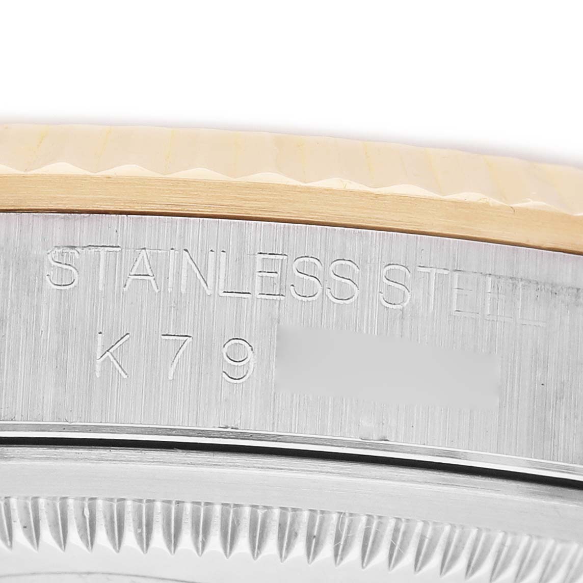 The image shows a close-up of the Rolex Datejust 116233 Men's Steel and Gold (two tone) Beige Dial's stainless steel case with engraved text and part of the fluted bezel.