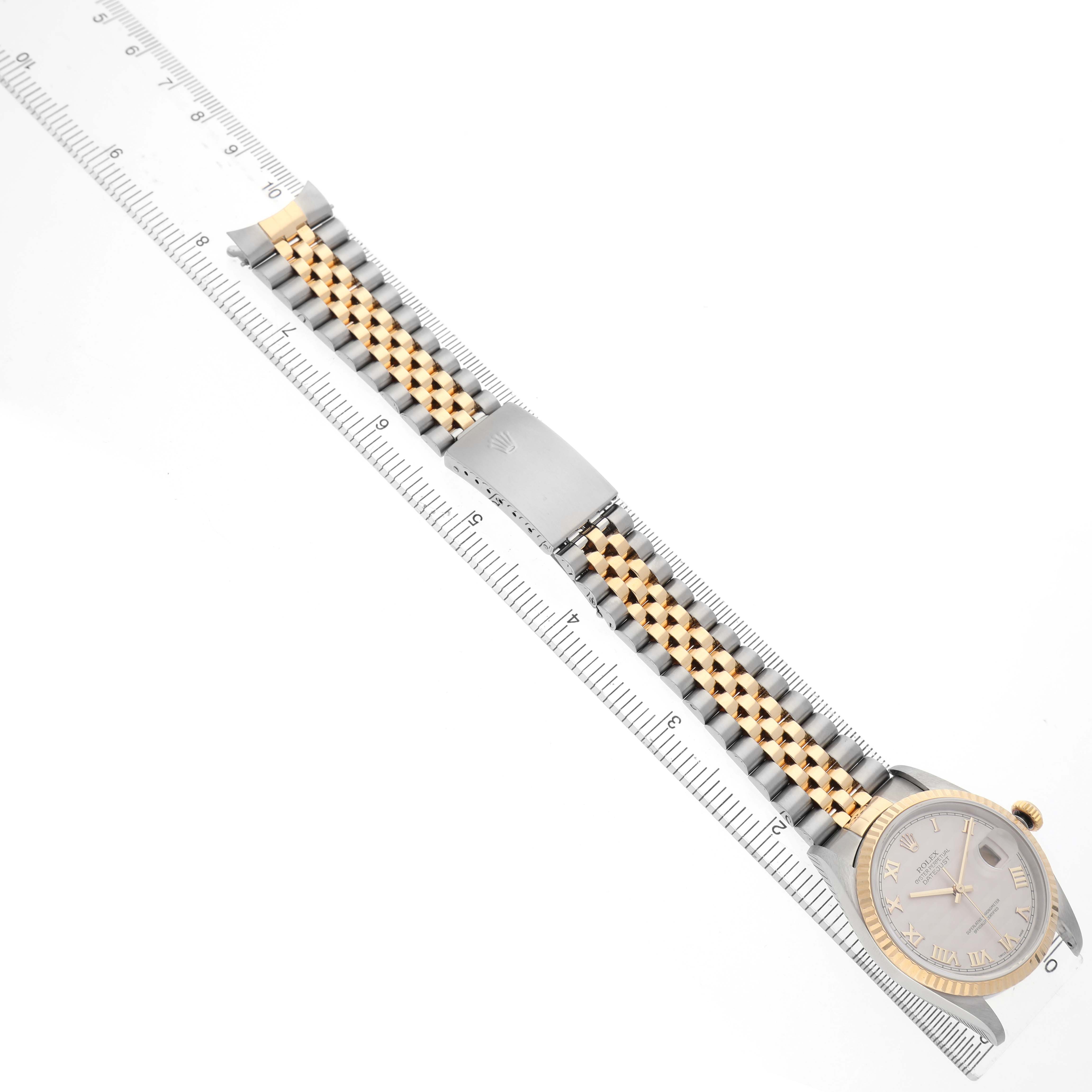 The Rolex Datejust 116233 Men's Steel and Gold (two tone) Beige Dial watch is displayed from above, showing the bracelet, clasp, and dial along a measuring ruler.