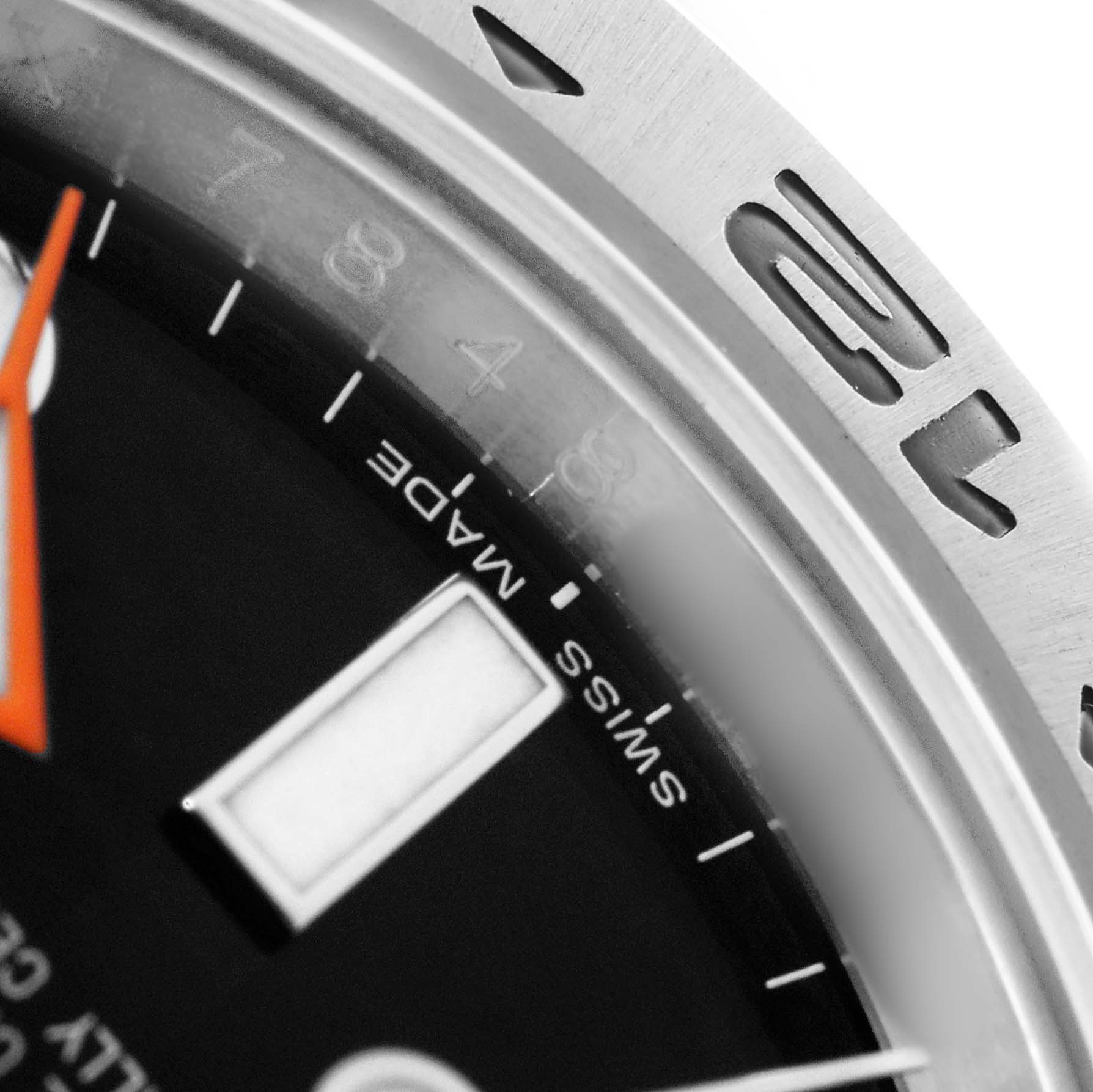 The image shows a close-up of the dial edge and bezel of a Rolex Explorer 216570 Men's Stainless Steel Black Dial watch, highlighting the hour markers and "Swiss Made" text.