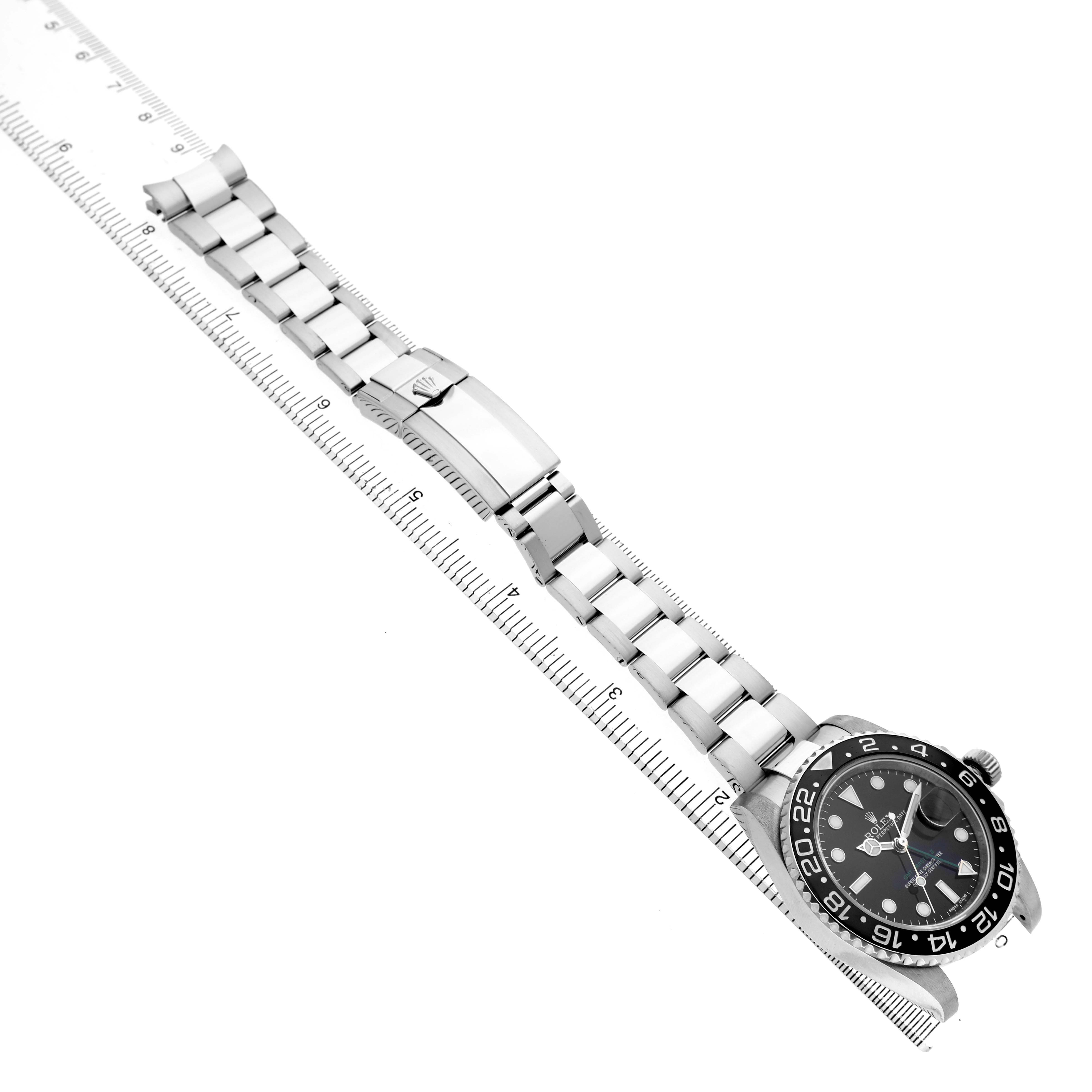 The Rolex GMT-Master 116710 Men's Stainless Steel Black Dial watch is shown at an oblique angle, displaying its face, bezel, bracelet, and clasp along a ruler.