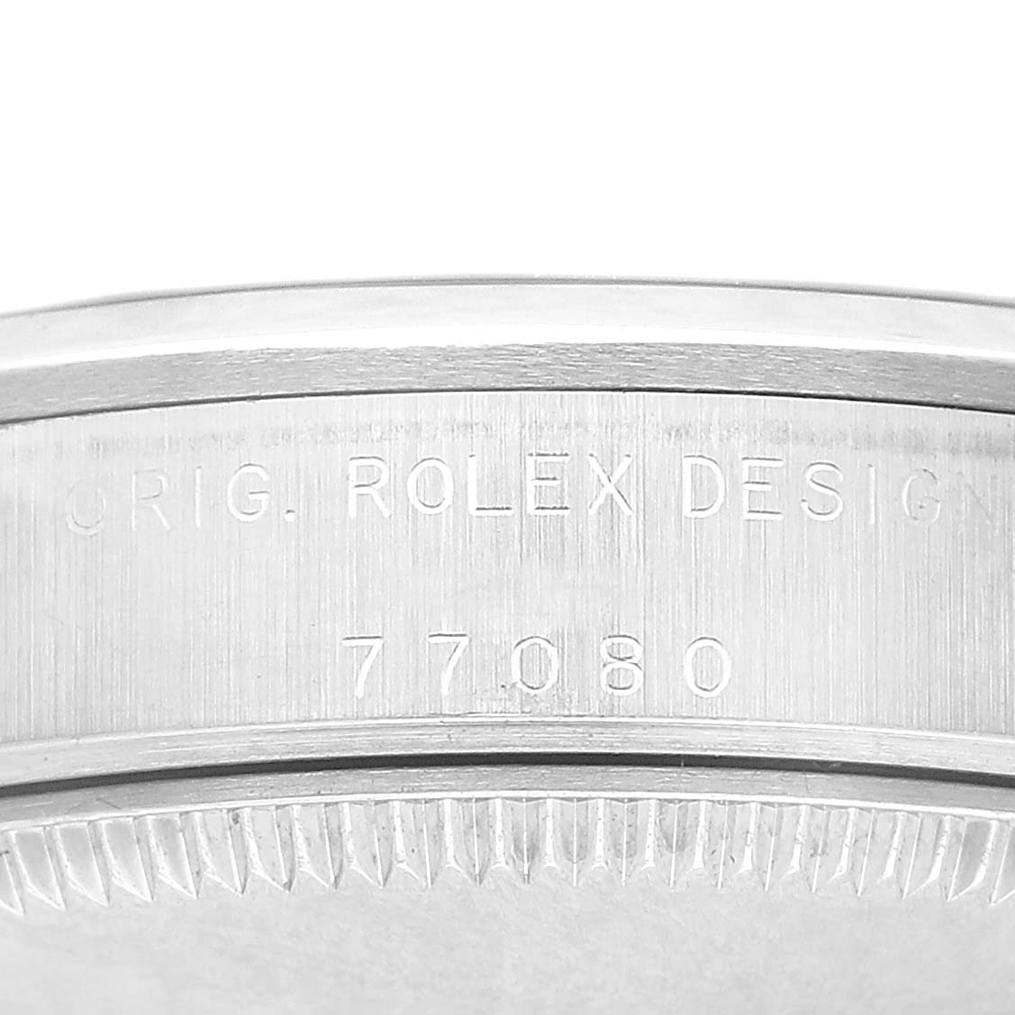 The image shows a close-up of the side detailing and bezel of the Oyster Perpetual model by Rolex, featuring engraved text.