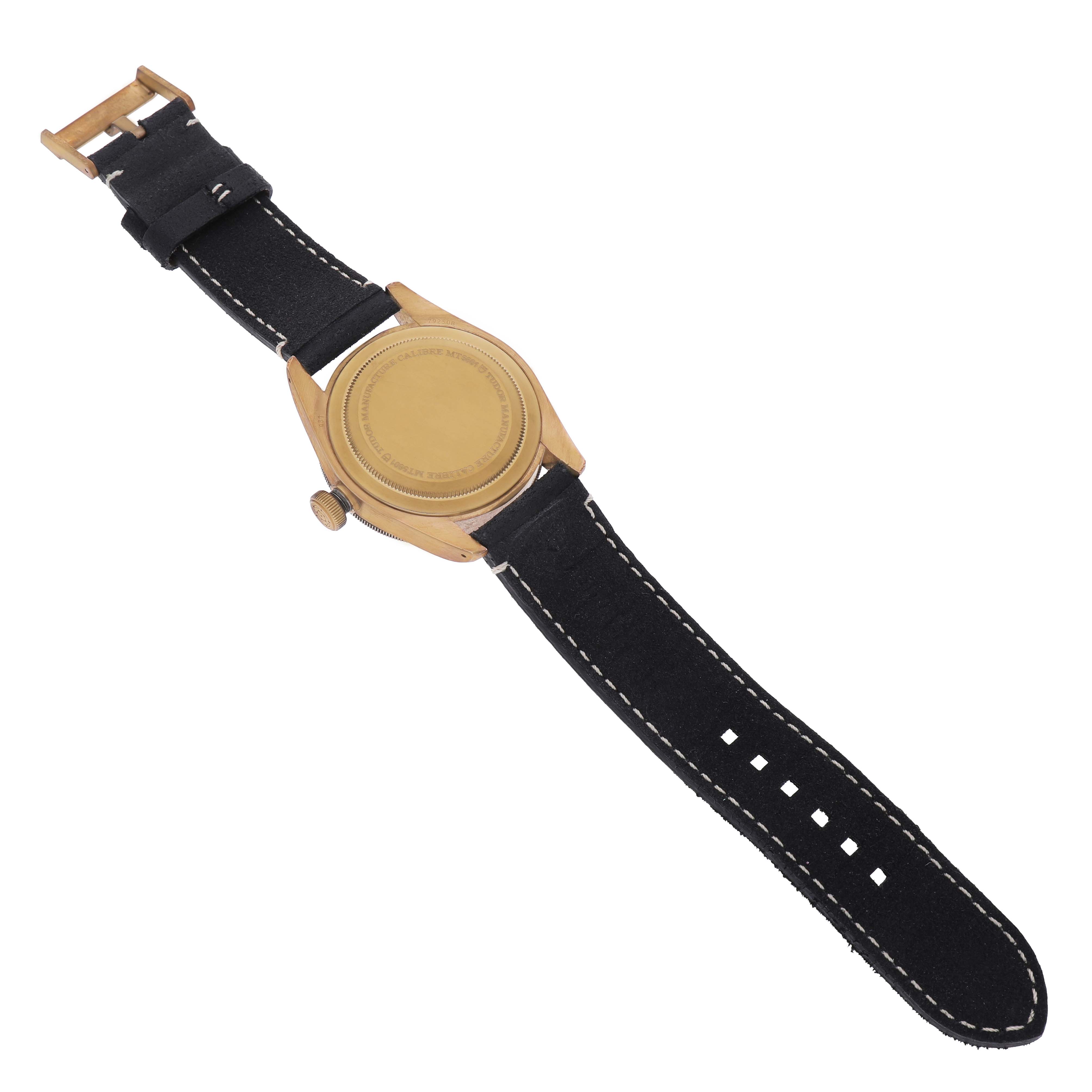 The image shows the back view of a Tudor Heritage Black Bay 79250BA Men's Bronze Grey Dial watch, highlighting the case back, crown, and strap.