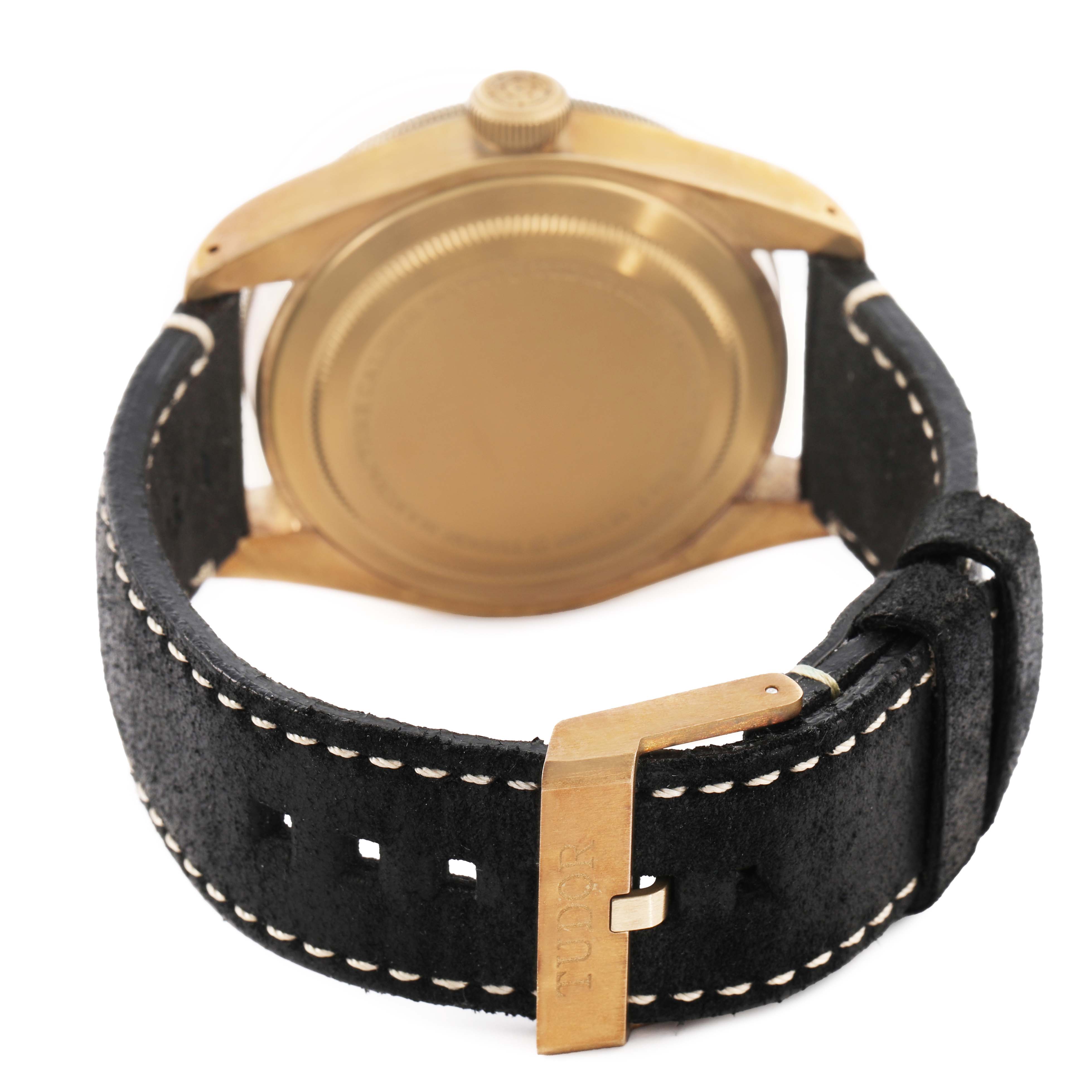 The image shows the back of a Tudor Heritage Black Bay 79250BA Men's Bronze Grey Dial watch, highlighting the case, crown, and black leather strap with a buckle.