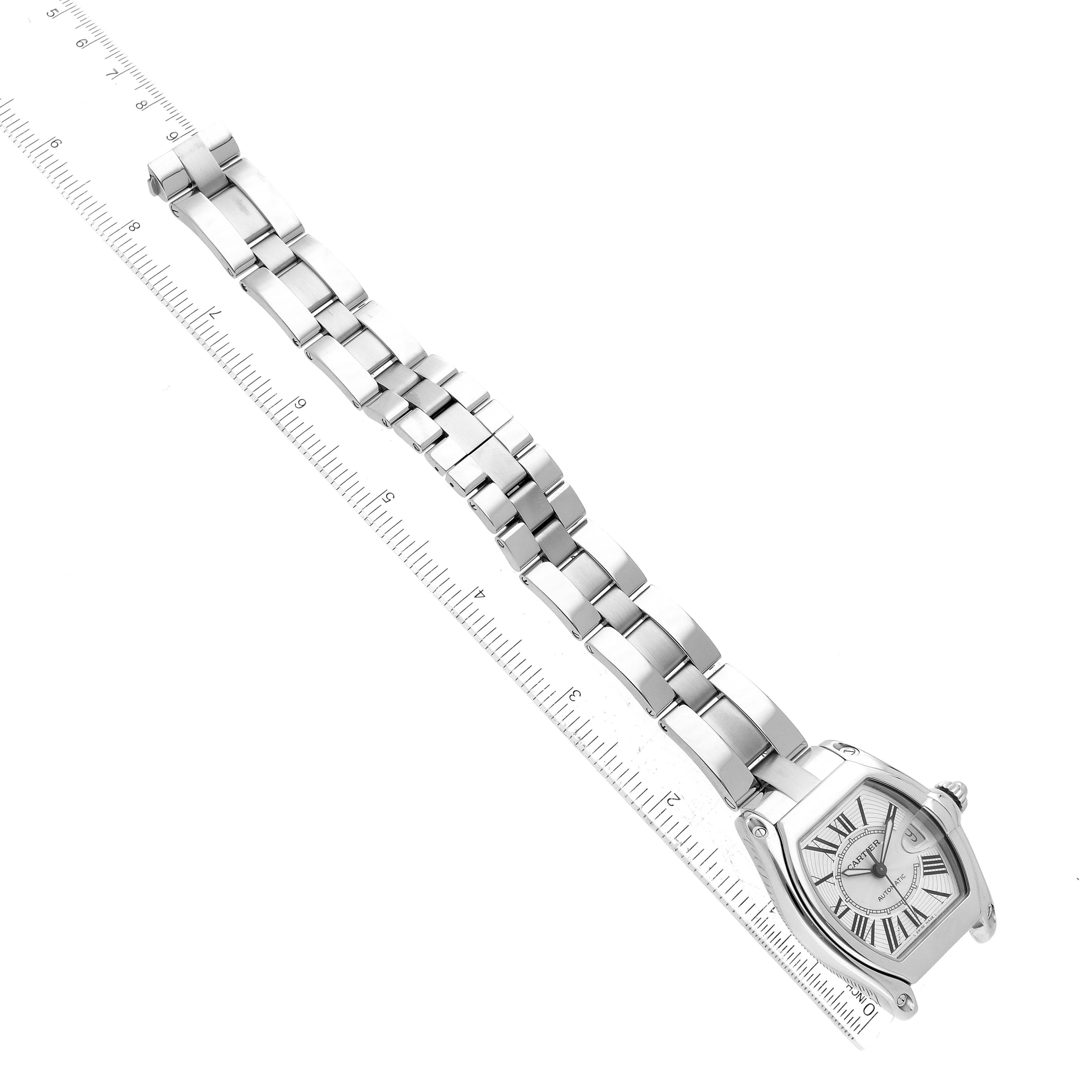 The image shows a Cartier Roadster W62025V3 Men's Stainless Steel Silver Dial W62025V3 Men's Stainless Steel Silver Dial watch laid flat alongside a ruler, displaying the watch face and metal link bracelet.
