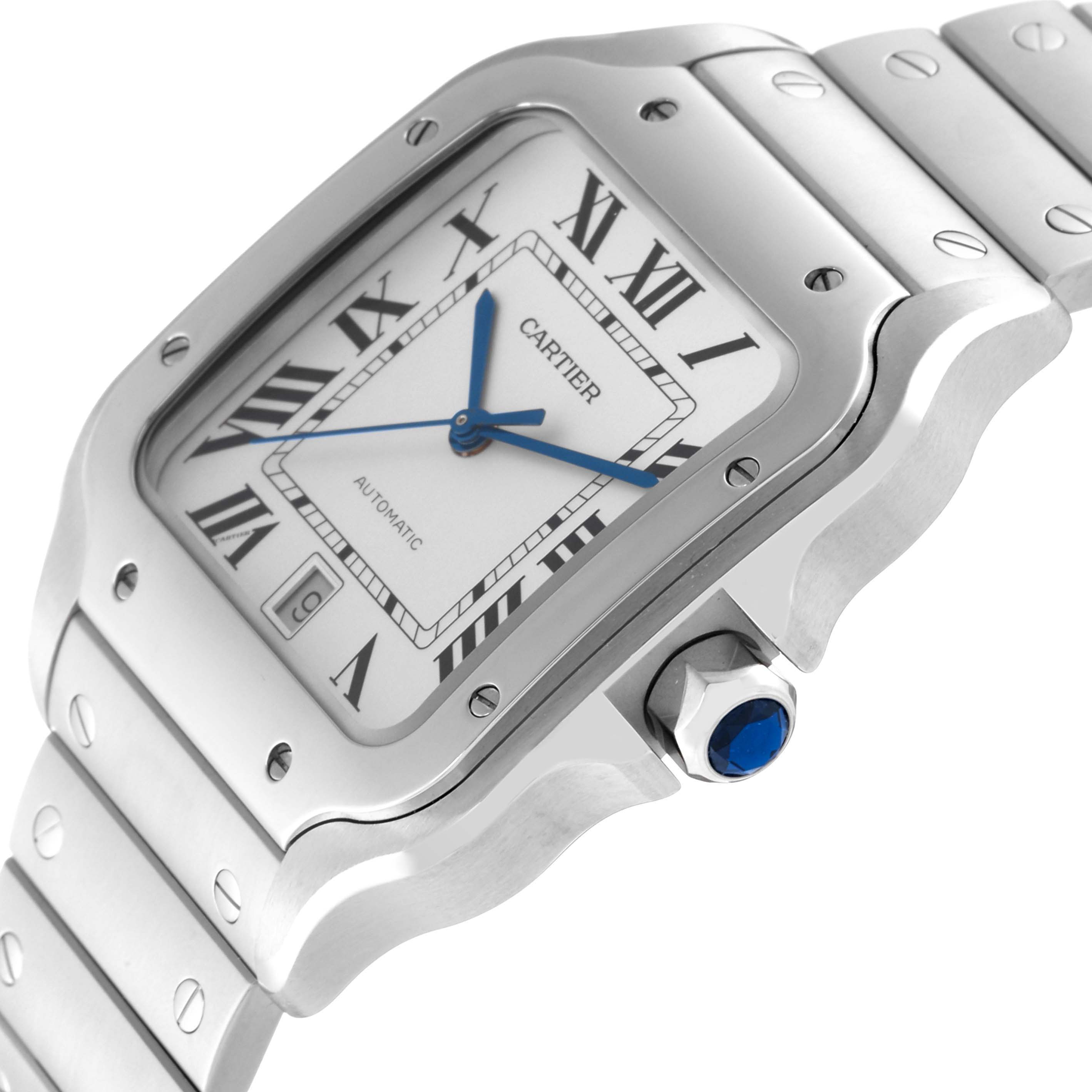 This Cartier Santos WSSA0009 Men
s Stainless Steel Silver Dial WSSA0009 Men
s Stainless Steel Silver Dial watch is shown at an angle showcasing its face, bezel, screw details, blue-tipped crown, and part of the bracelet.