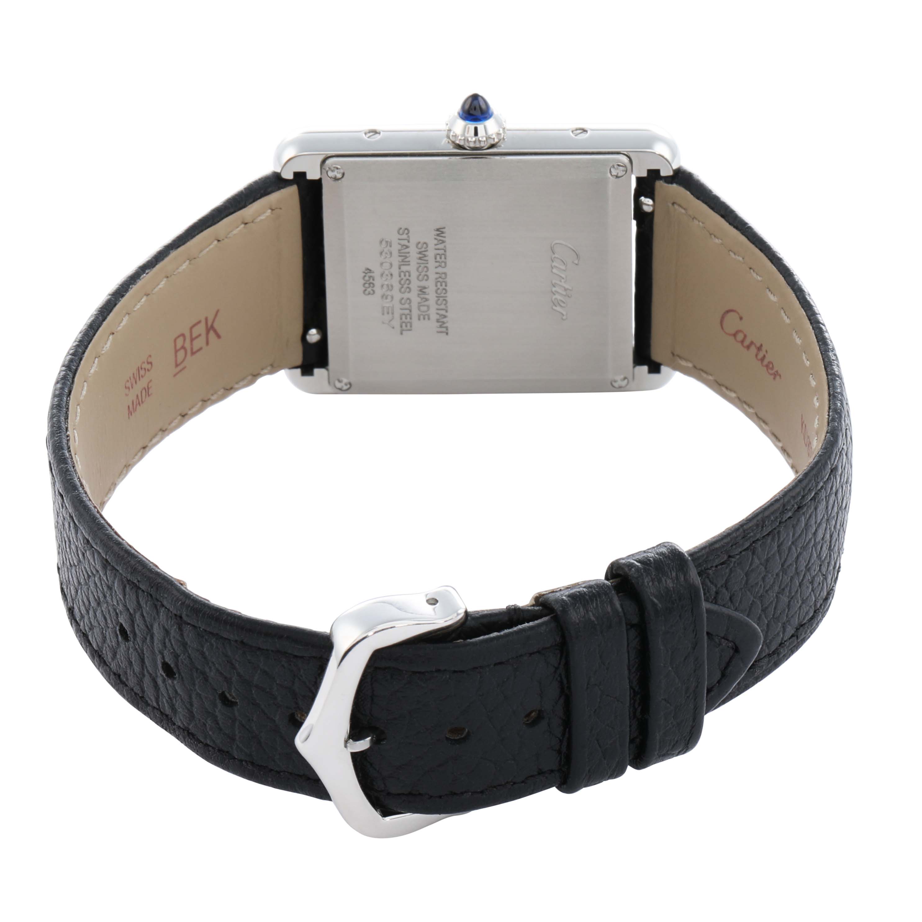 The image shows the back of a Cartier Tank Must WSTA0120 Men's Stainless Steel Silver Dial watch, highlighting the case back, crown, and black leather strap.