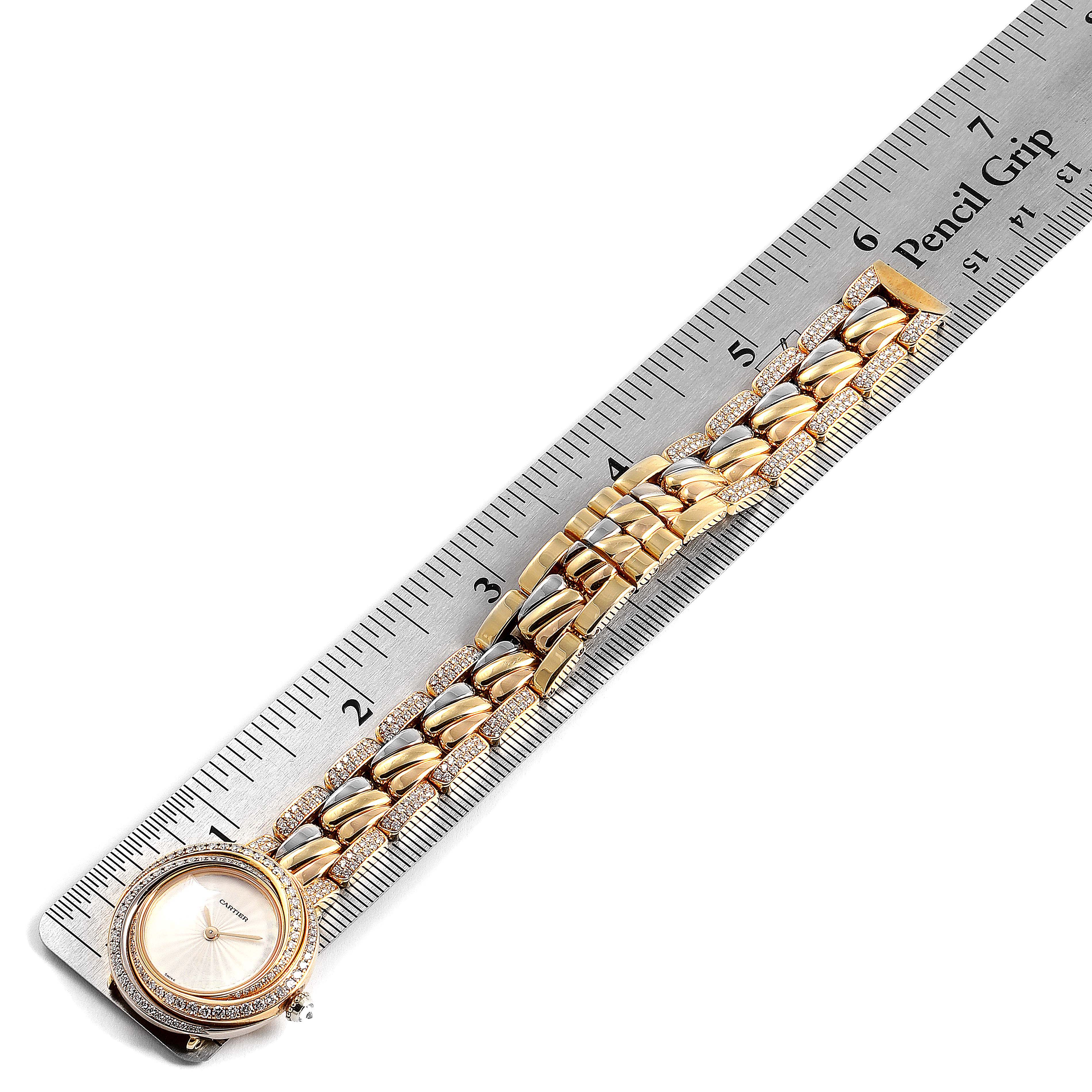 The Trinity model by Cartier is shown from a top view, featuring the watch face and bracelet measured beside a ruler.