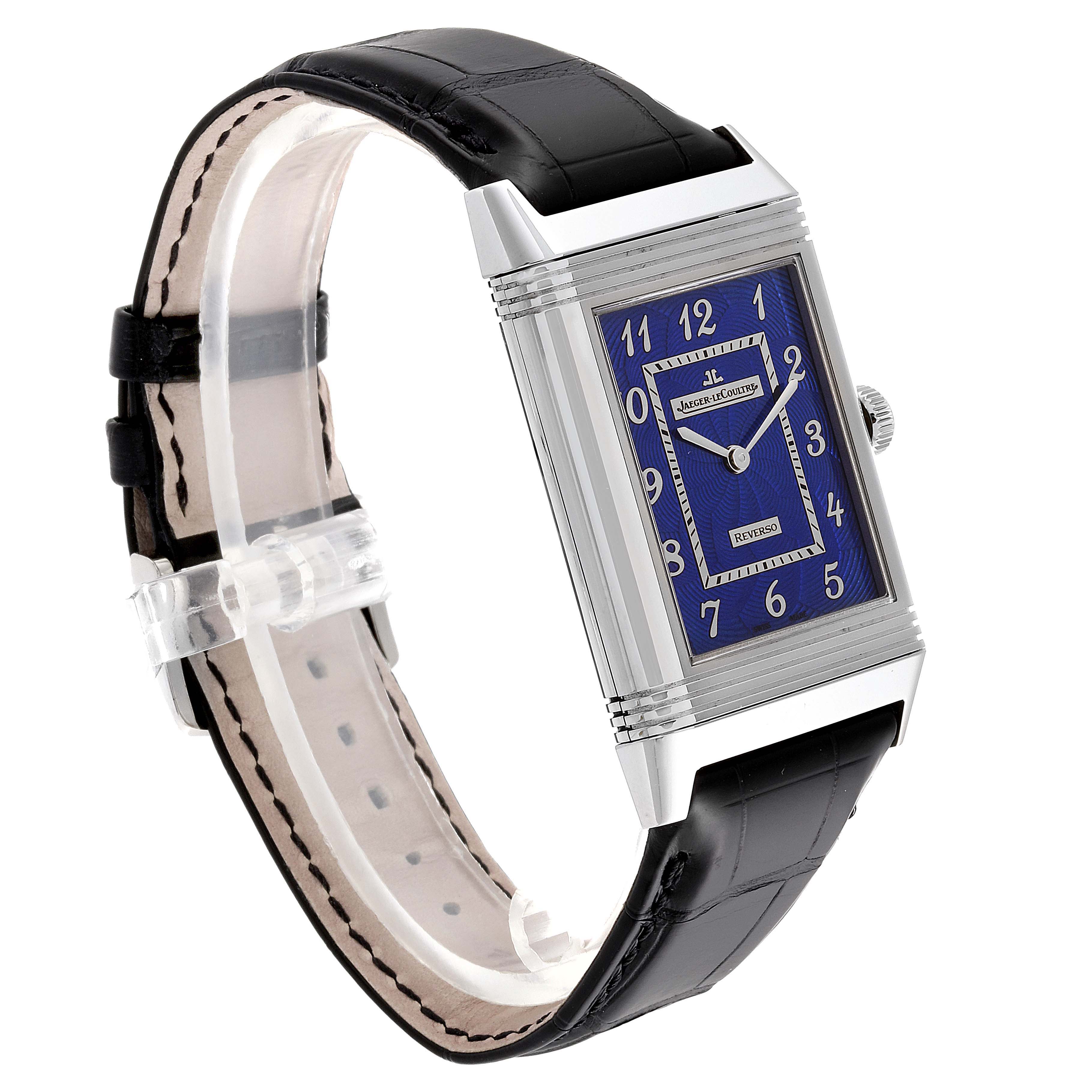The image shows a Jaeger LeCoultre Reverso Q33735E1 Men's White Gold Blue Dial Q33735E1 Men's White Gold Blue Dial watch at a slight angle, highlighting its rectangular case, blue dial, and black leather strap.