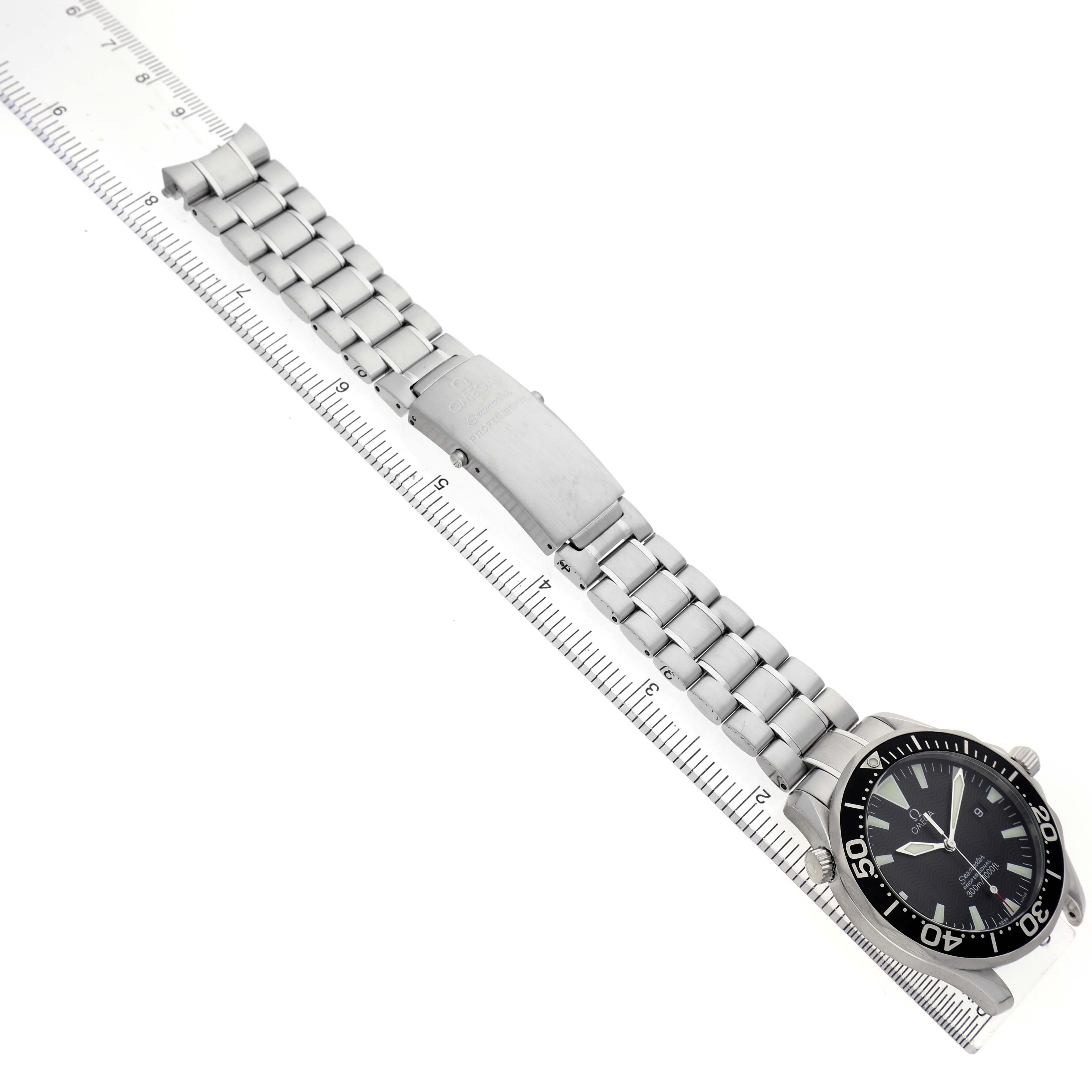 The Omega Seamaster 2264.50.00 Men's Stainless Steel Black Dial watch is shown laid flat with its full metal bracelet and clasp visible, aligned along a ruler.