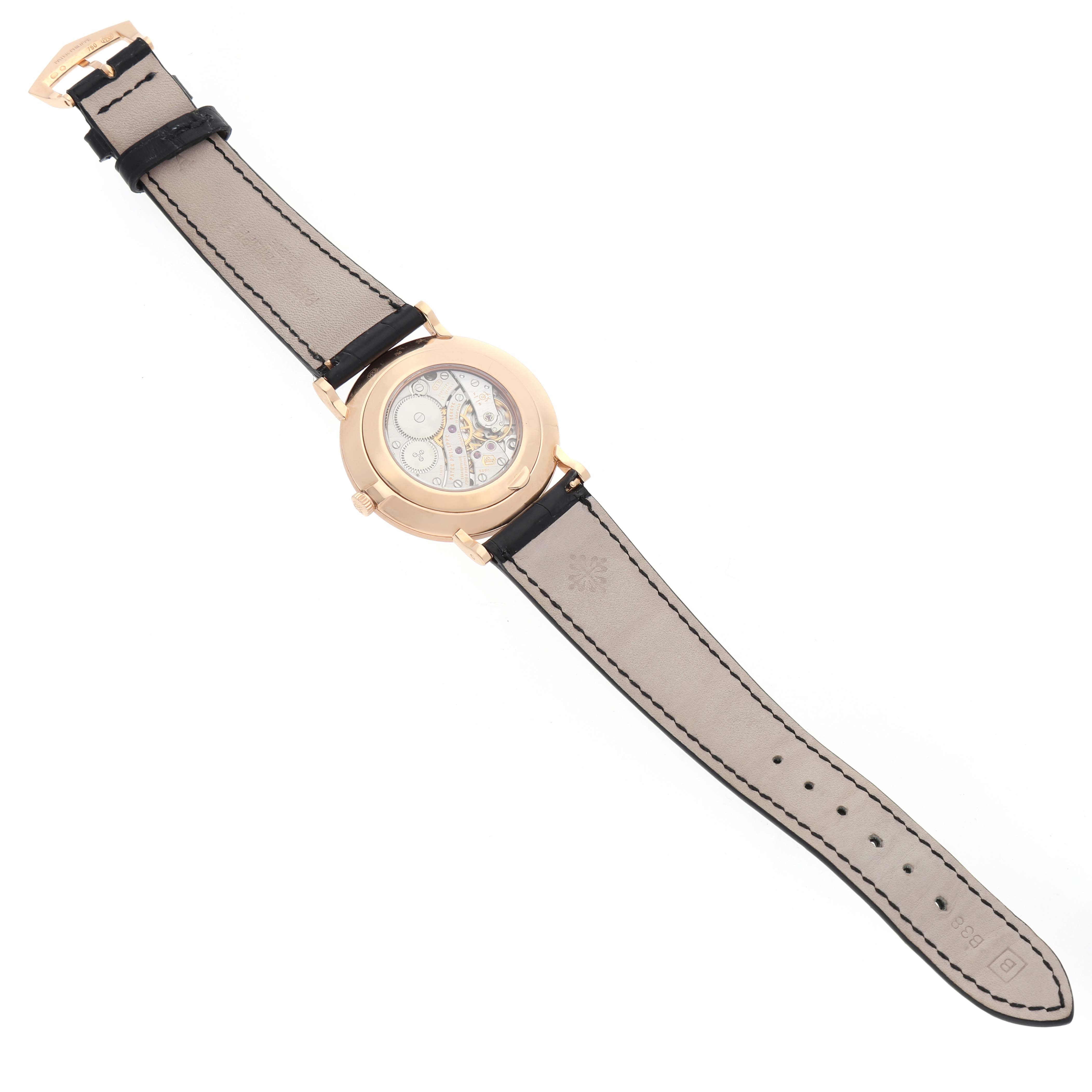 The Patek Philippe Calatrava 5119R Men's Rose Gold White Dial watch is shown from the back, highlighting the intricate movement through its transparent case back.