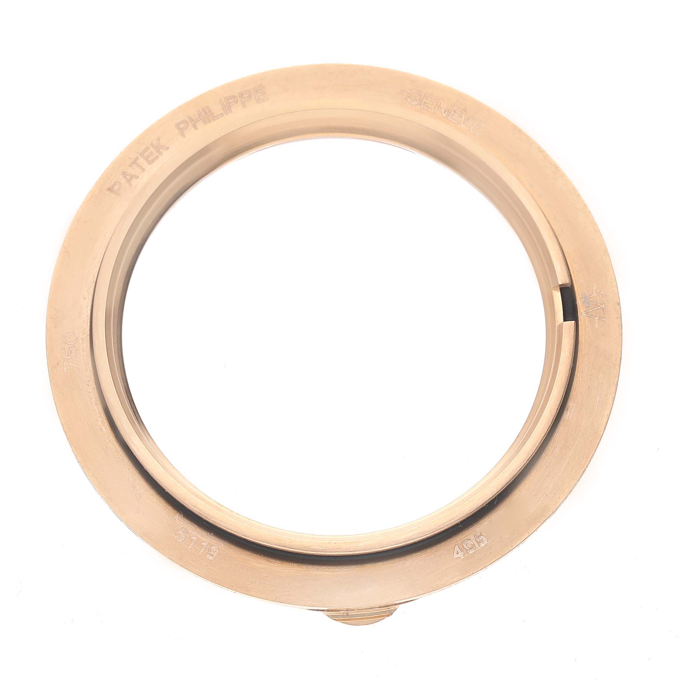 The image shows a top-view of a Patek Philippe Calatrava 5119R Men's Rose Gold White Dial bezel, highlighting its circular shape and engravings.