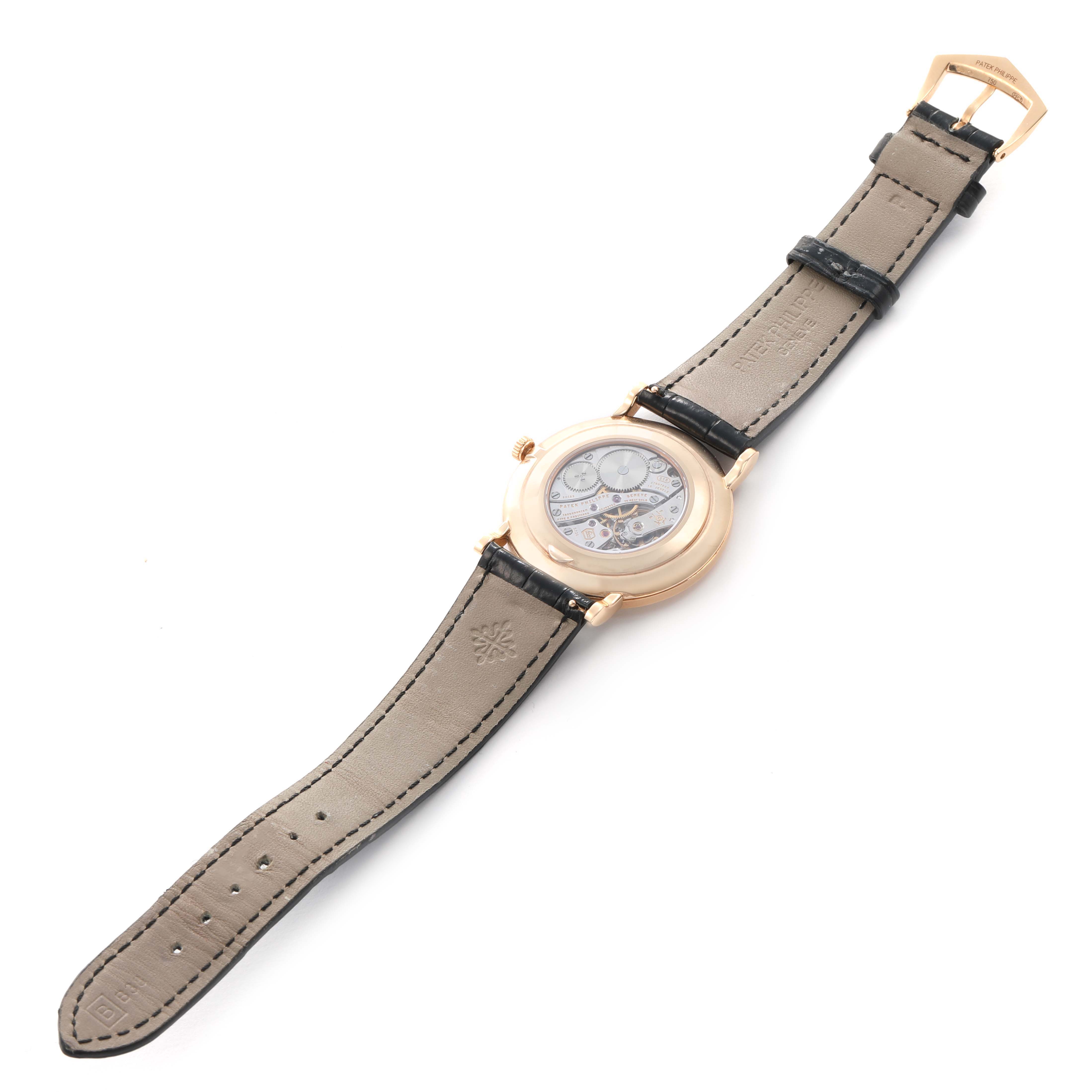 The Patek Philippe Calatrava 5119R Men's Rose Gold White Dial watch is shown from the back, displaying its movement and leather strap.