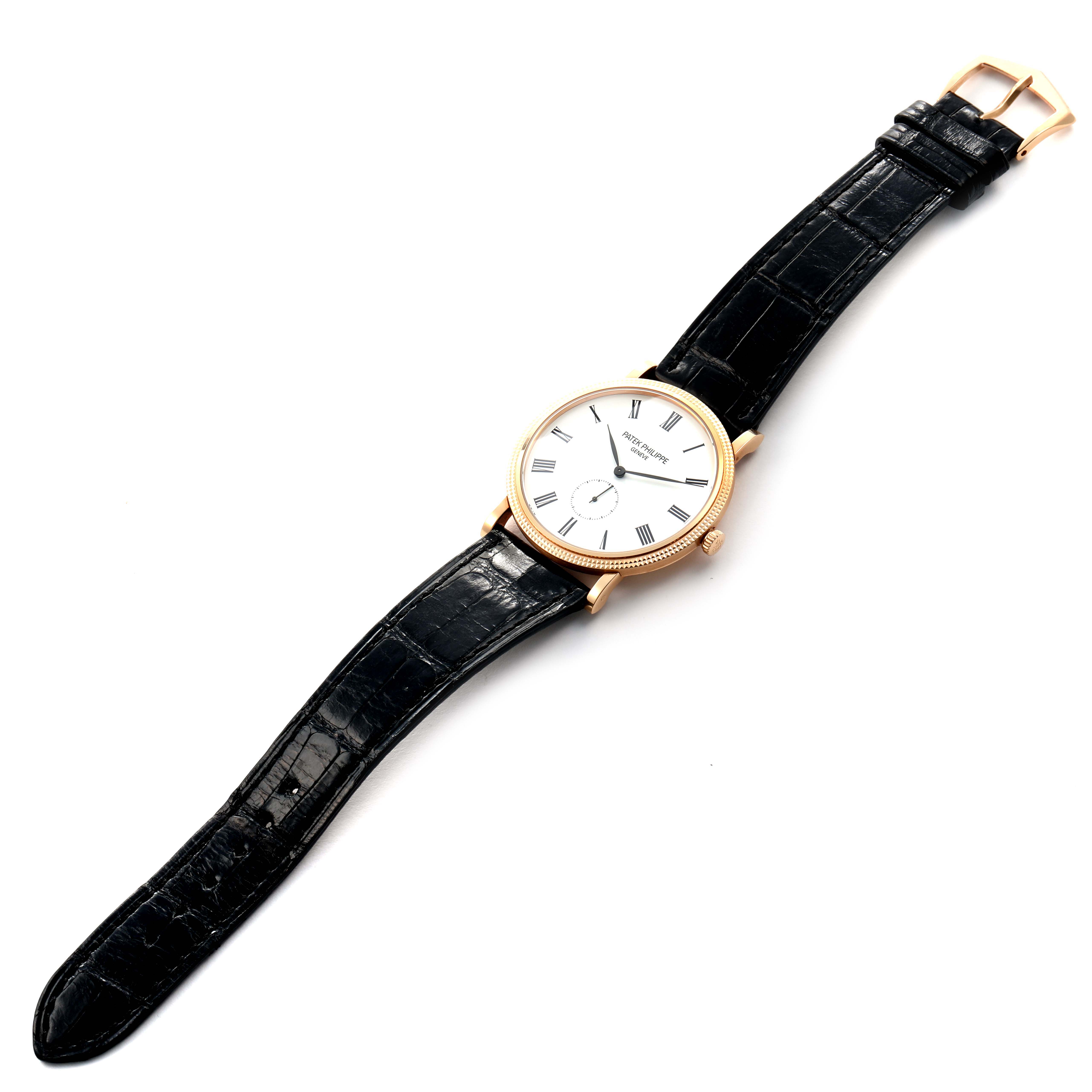 The Patek Philippe Calatrava 5119R Men's Rose Gold White Dial watch is shown at a slight angle, displaying its face, black strap, and clasp.