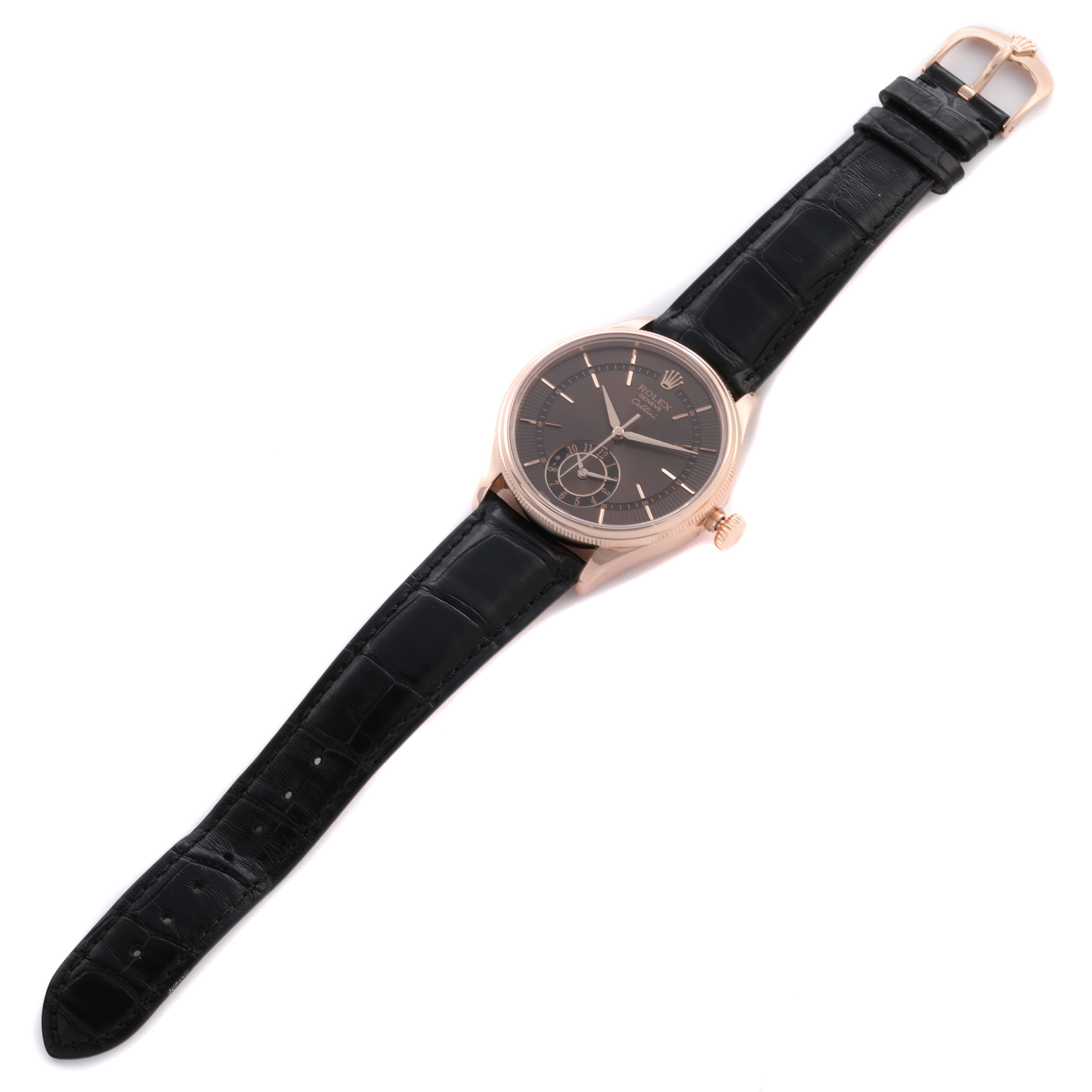 The Rolex Cellini 50525 Men's Rose Gold Brown Dial watch is shown from a top-down angle, displaying the black dial, gold case, and black leather strap.