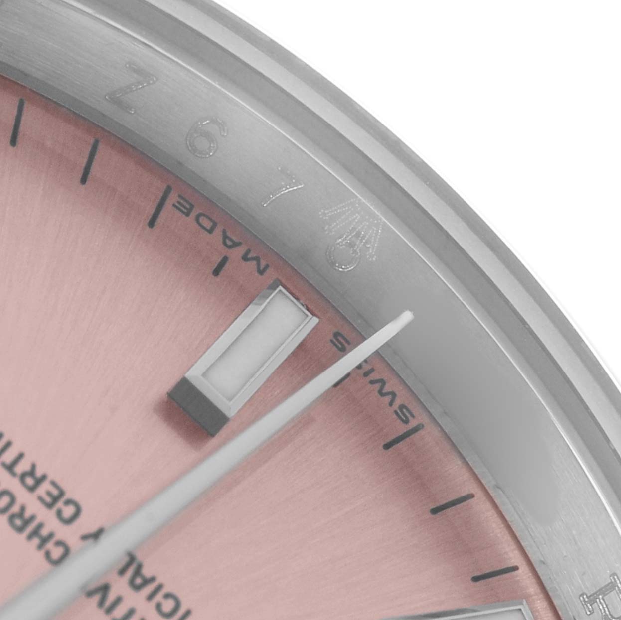 The image shows a close-up angle of the dial edge and bezel of a Rolex Date 115200 Men's Stainless Steel Pink Dial watch, highlighting the logo and markers.