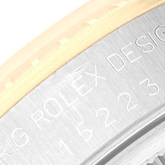 The image shows a close-up of the bezel and case back edge with engraved text of a Rolex Date 15223 Men's Steel and Gold (two tone) Champagne Dial 15223 Men's Steel and Gold (two tone) Champagne Dial watch.