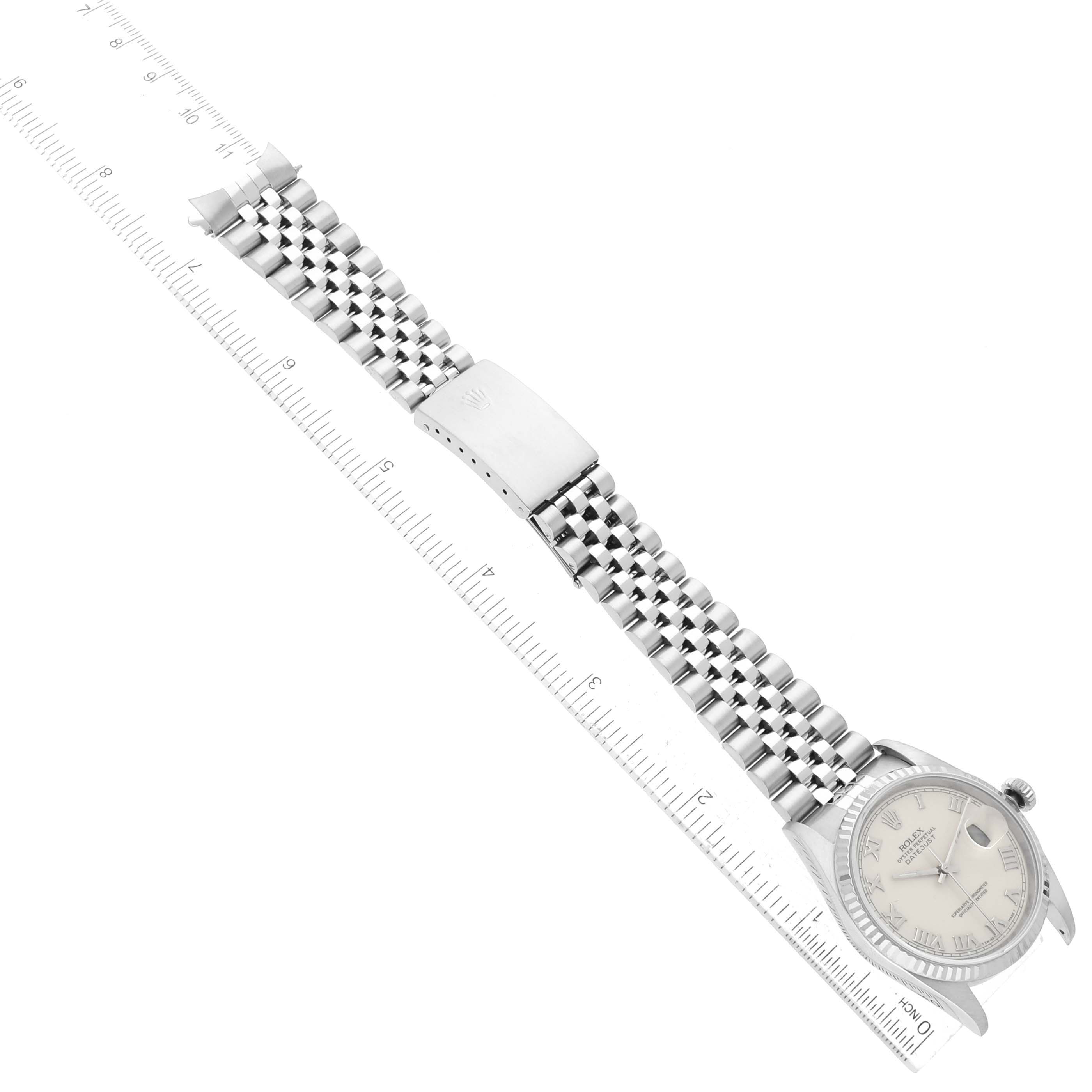 This image shows the Rolex Datejust 16234 Men
s Stainless Steel White Dial 16234 Men
s Stainless Steel White Dial watch from an overhead angle, highlighting the watch face, band, and clasp against a ruler.