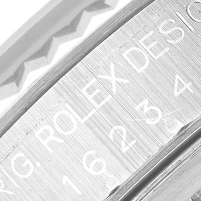 This close-up image of the Rolex Datejust 16234 Men
s Stainless Steel White Dial 16234 Men
s Stainless Steel White Dial watch shows part of the brushed metal caseback with engraved text and a portion of the bezel.