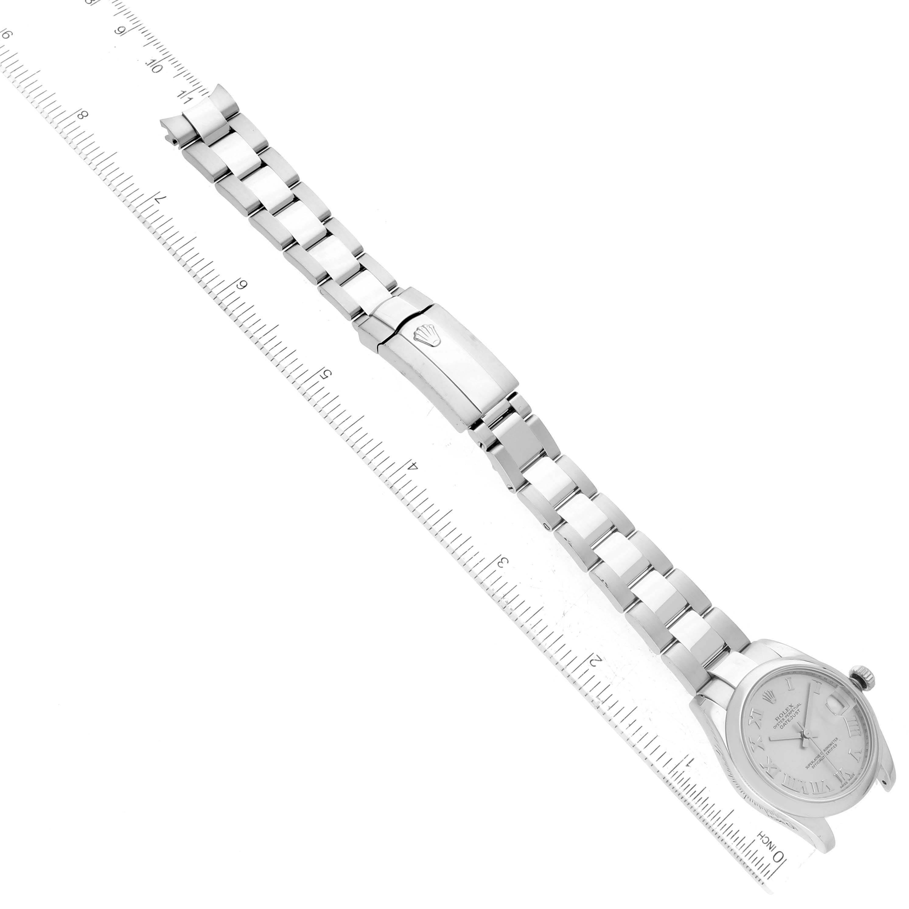 The image shows a top-down view of a Mid-Size Rolex watch, featuring the bracelet and clasp with a ruler for scale.