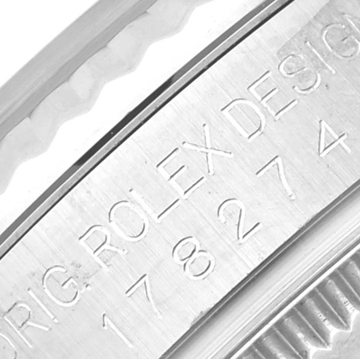 This close-up shows the engraved side of a Mid-Size Rolex watch case with a portion of the fluted bezel.