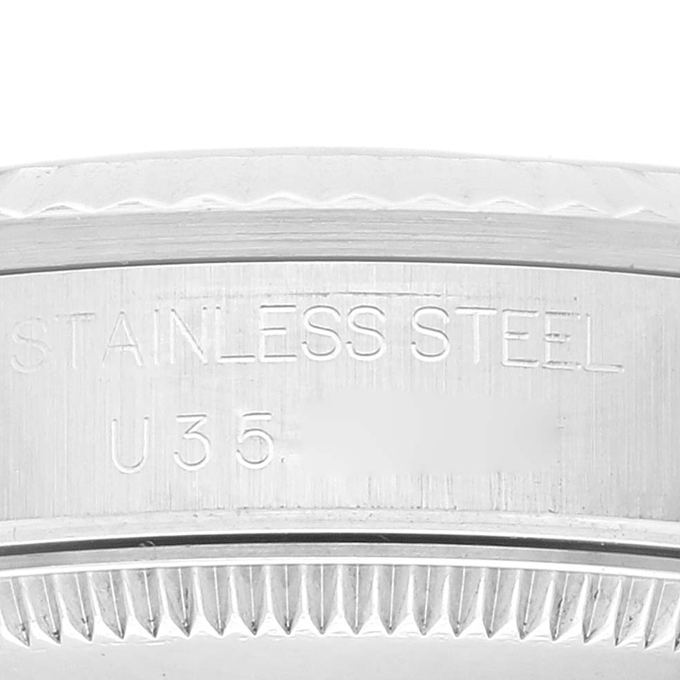 The image shows a close-up of the casing side of a Mid-Size Rolex watch, displaying the "STAINLESS STEEL" engraving and part of the bezel.