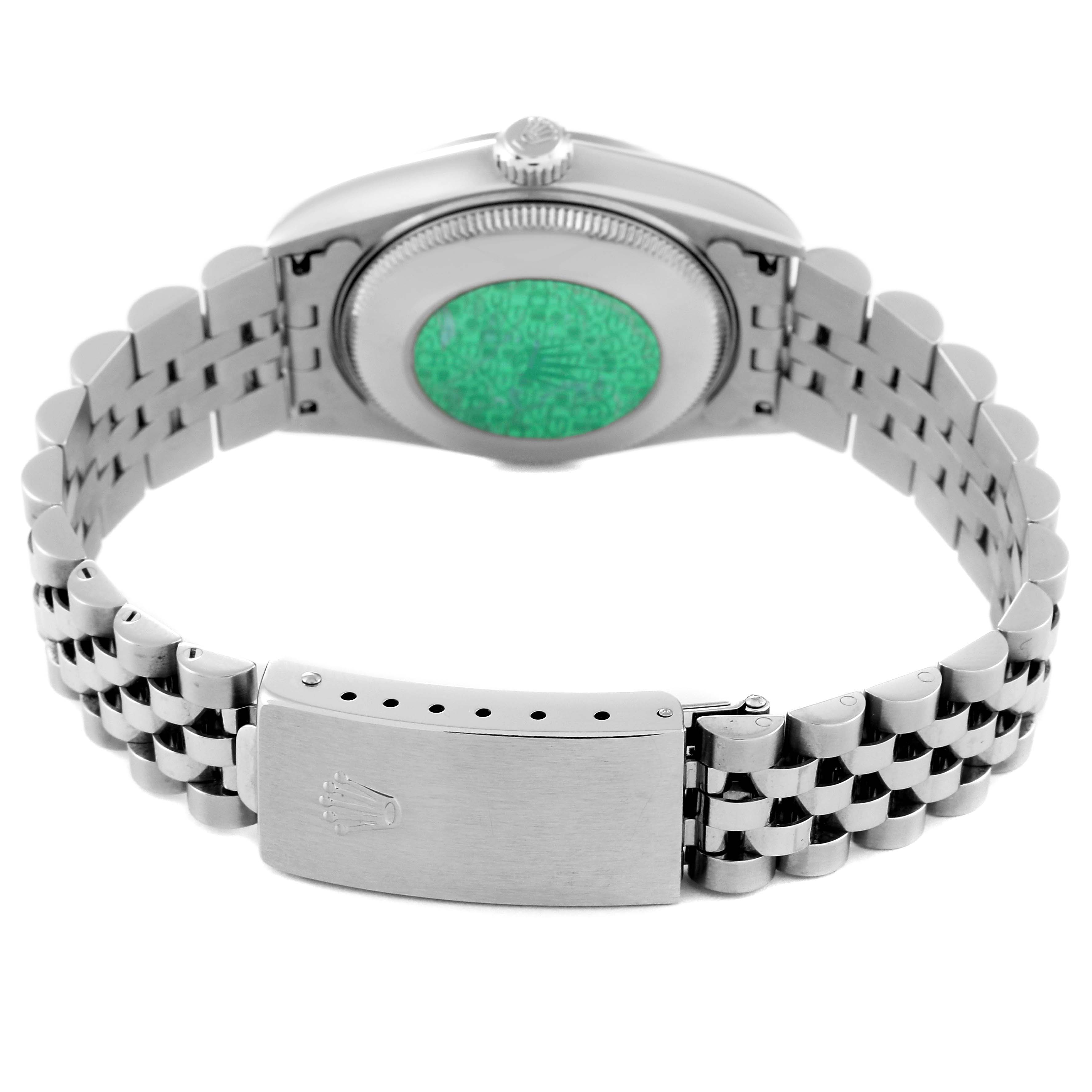 This image shows the backside and clasp of a mid-size Rolex watch's bracelet, highlighting the watch's case and green hologram sticker.