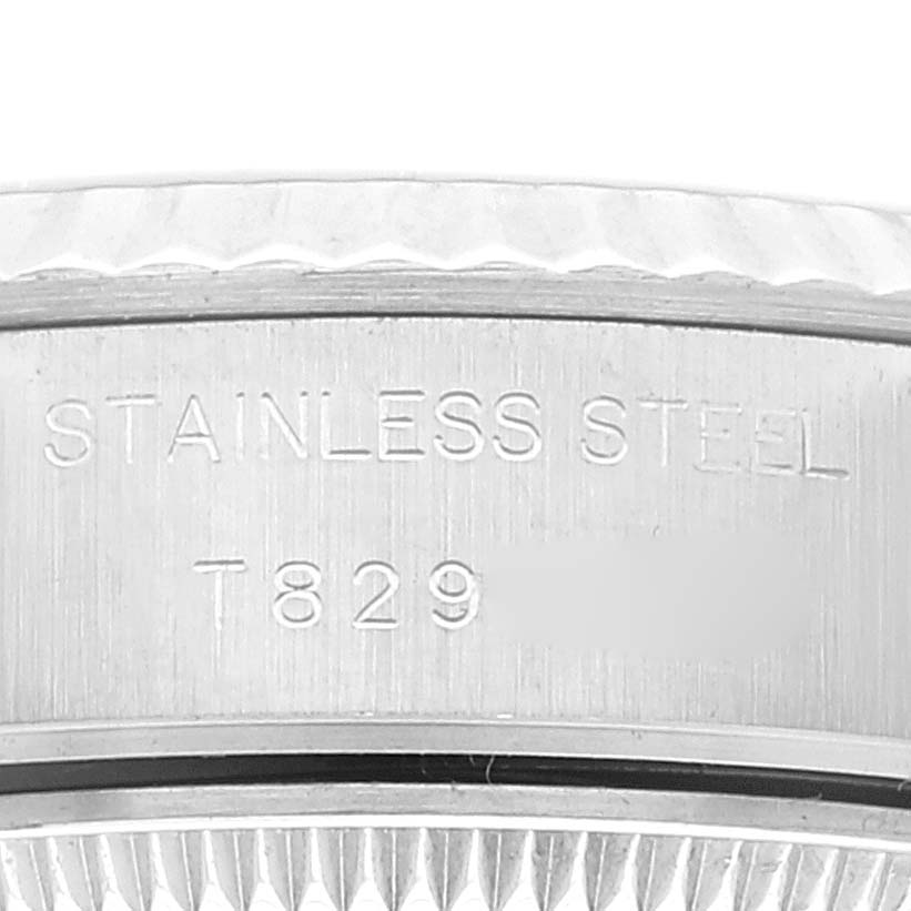 This image shows a close-up view of the side of the stainless steel case of a Rolex Datejust 69174 Women's Stainless Steel Pink Dial 69174 Women's Stainless Steel Pink Dial watch, revealing part of its engraved markings.