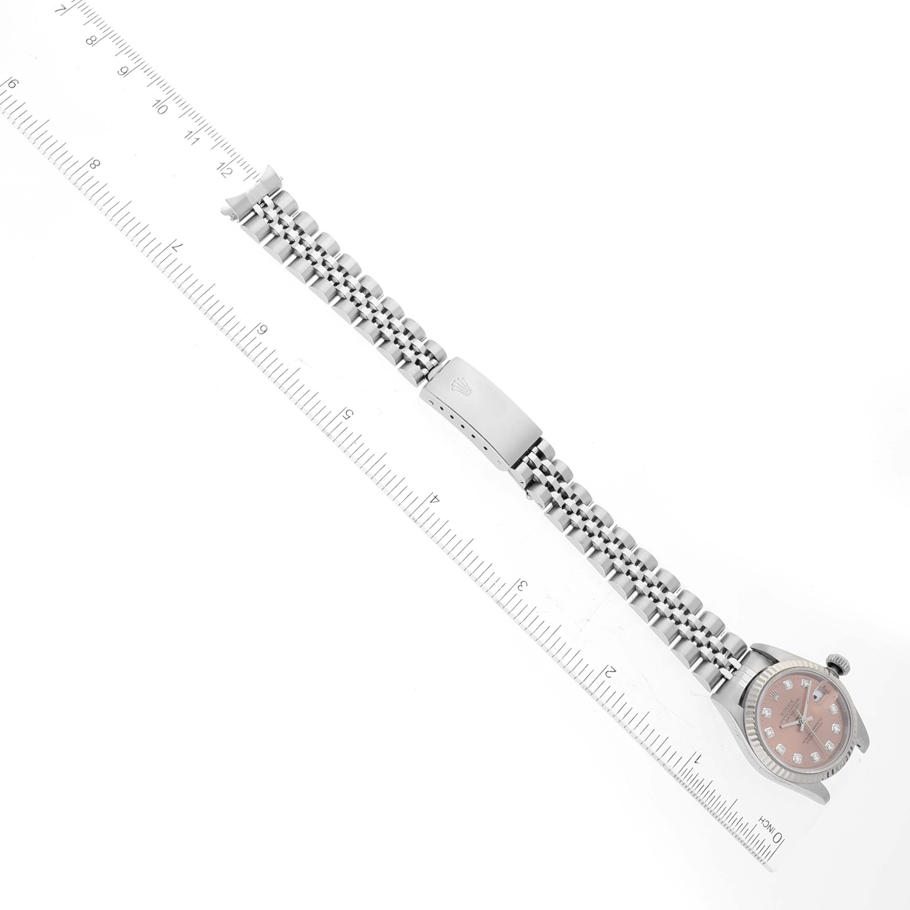 This image shows a side view of the Rolex Datejust 69174 Women's Stainless Steel Pink Dial 69174 Women's Stainless Steel Pink Dial watch with its bracelet fully extended next to a ruler for scale.