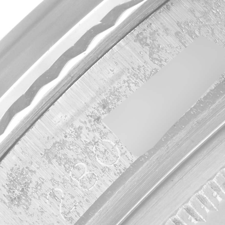 This close-up image shows the engraved and textured edge of a Rolex Vintage Collection 1601 Men's Stainless Steel Silver Dial 1601 Men's Stainless Steel Silver Dial model watch's bezel or caseback.