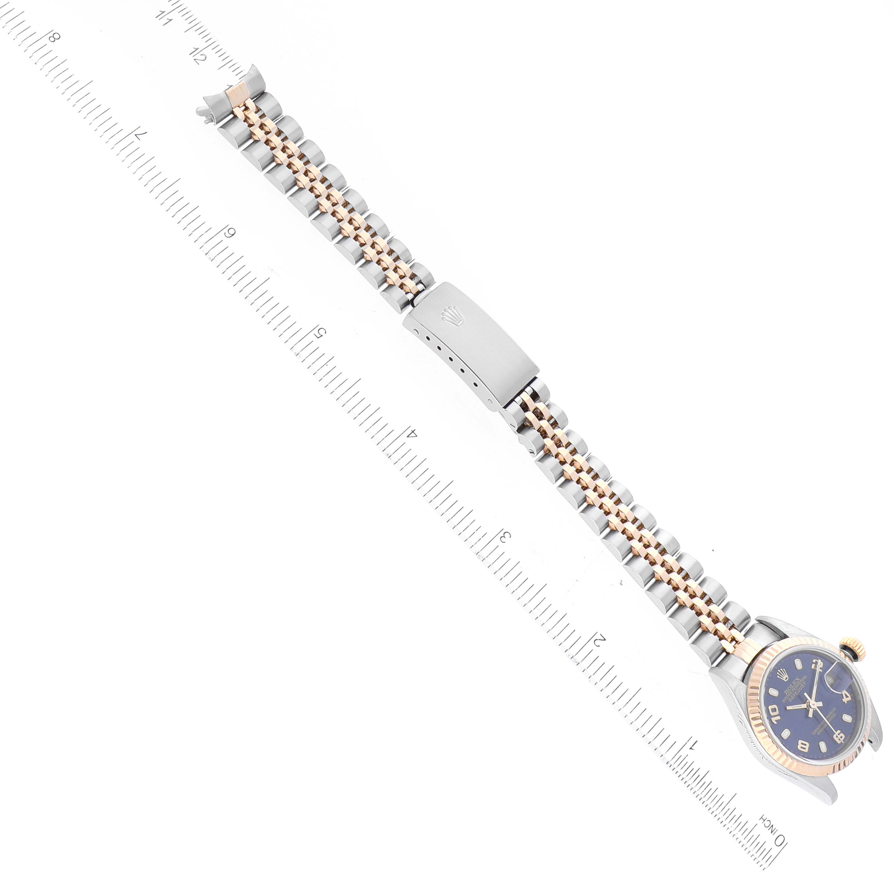 The image displays a Rolex Datejust 79173 Women's Steel and Gold (two tone) Blue Dial 79173 Women's Steel and Gold (two tone) Blue Dial watch from a top-down angle, featuring the watch face, bracelet, and clasp alongside a ruler for scale.