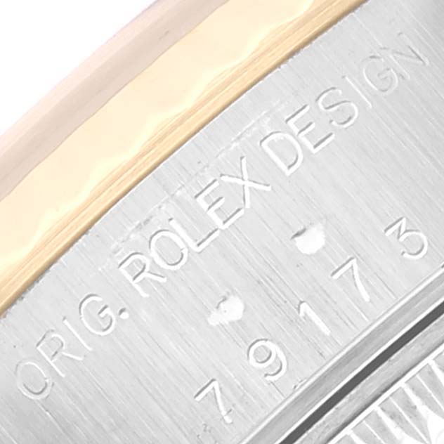 The image shows a close-up of the case back edge of a Rolex Datejust 79173 Women's Steel and Gold (two tone) Blue Dial 79173 Women's Steel and Gold (two tone) Blue Dial model, revealing the engraved "ROLEX DESIGN" and model number.